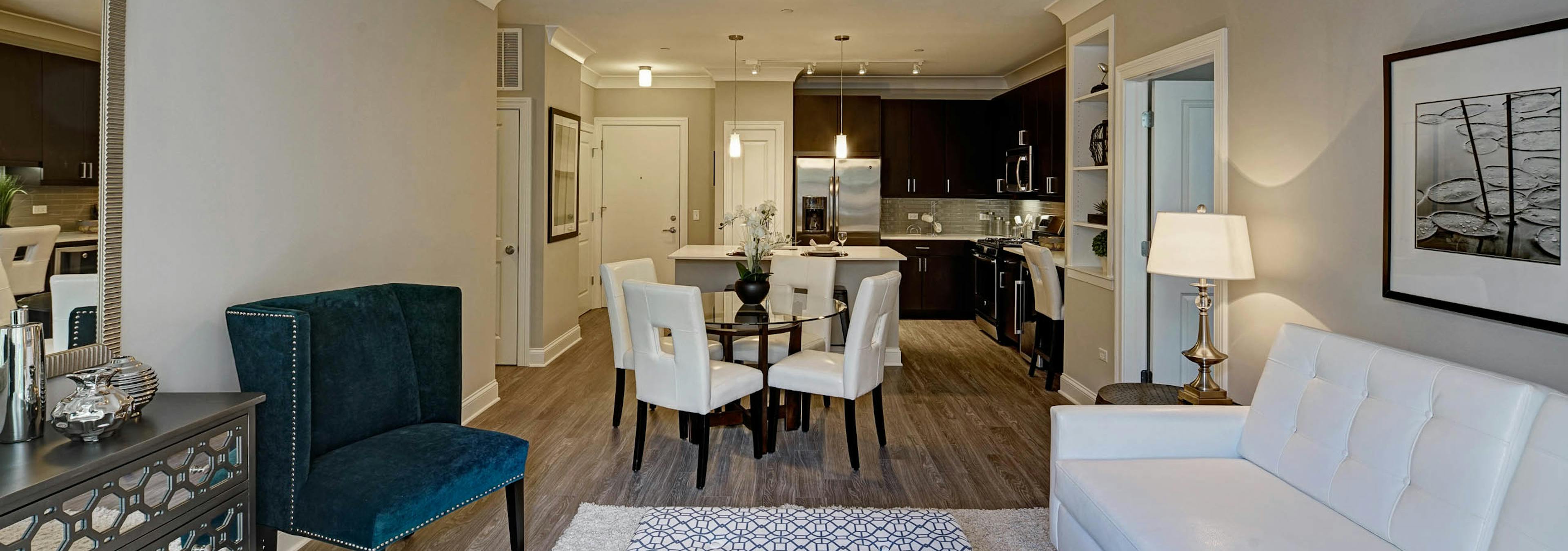 Interior view of AMLI Deerfield apartment community living room into dining room and kitchen with custom crown molding