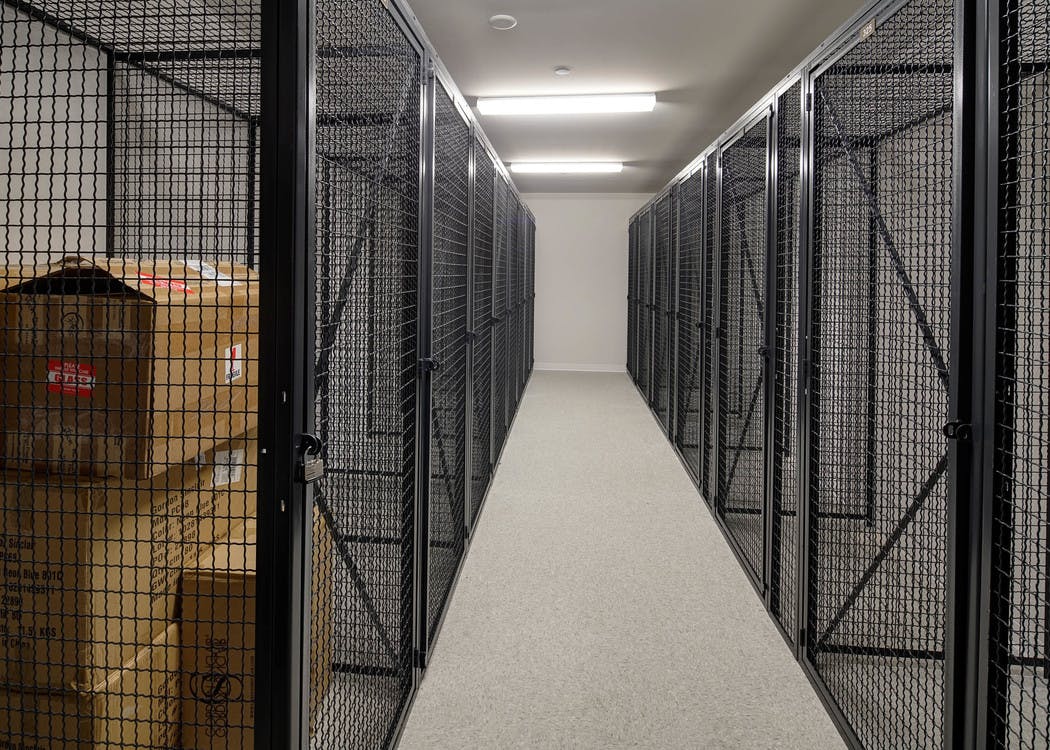 Interior view of large black storage cages on each side of the room with one containing boxes at AMLI Deerfield