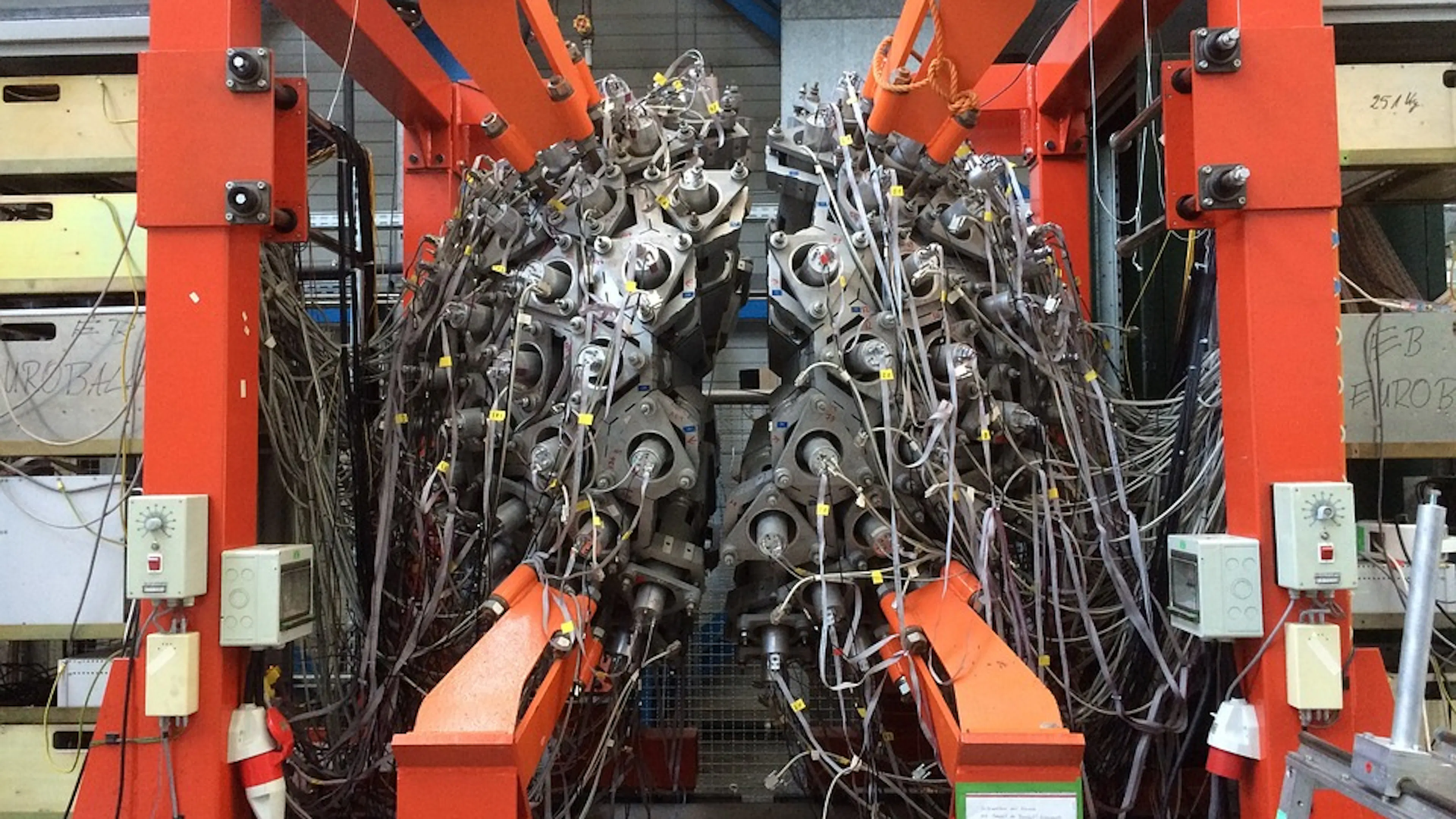 A complex particle accelerator as viewed from behind where all the cables are connected to exterior machinery
