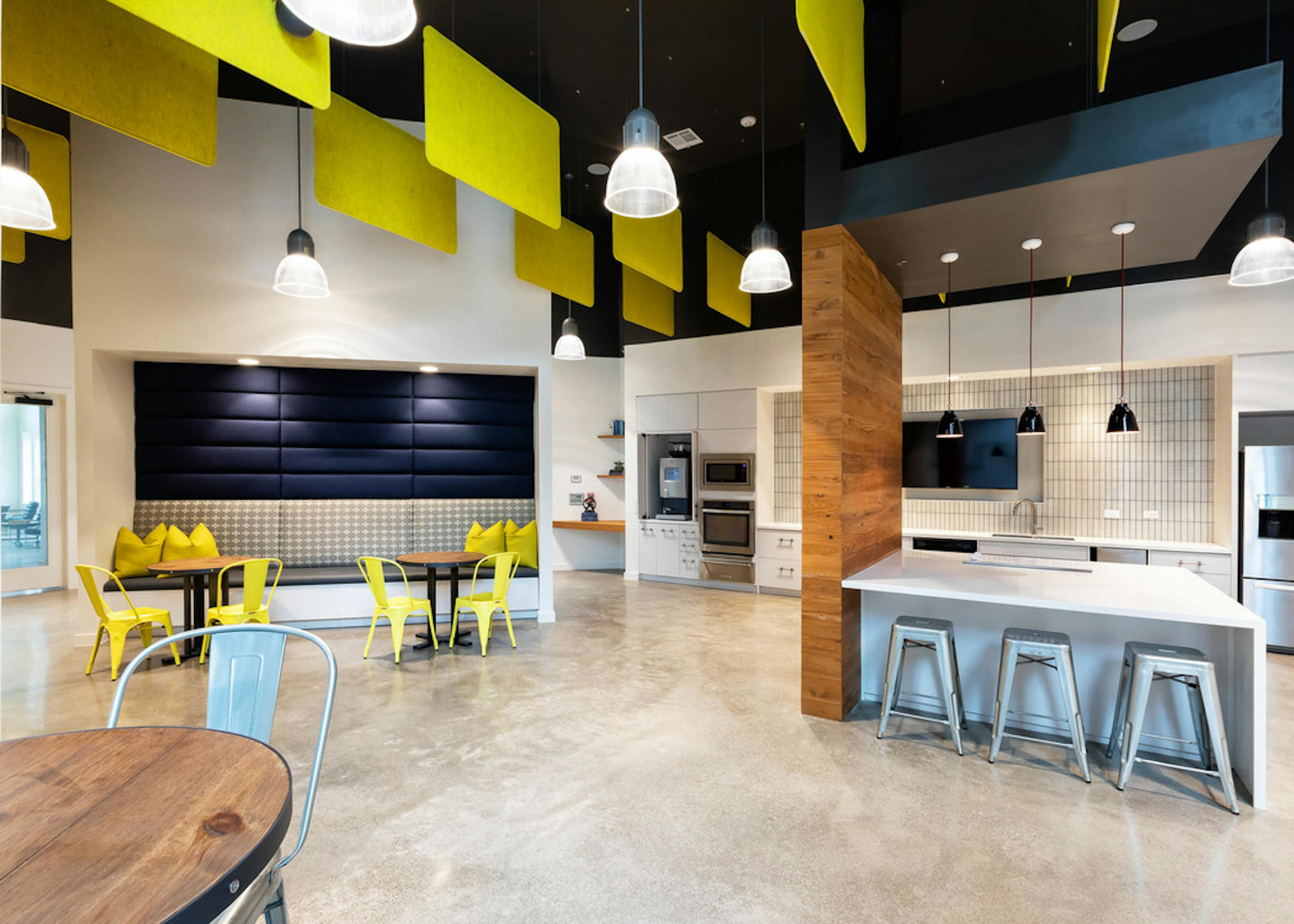 Interior of clubroom at AMLI Frisco Crossing apartment building with coffee station and serving kitchen with booth and tables
