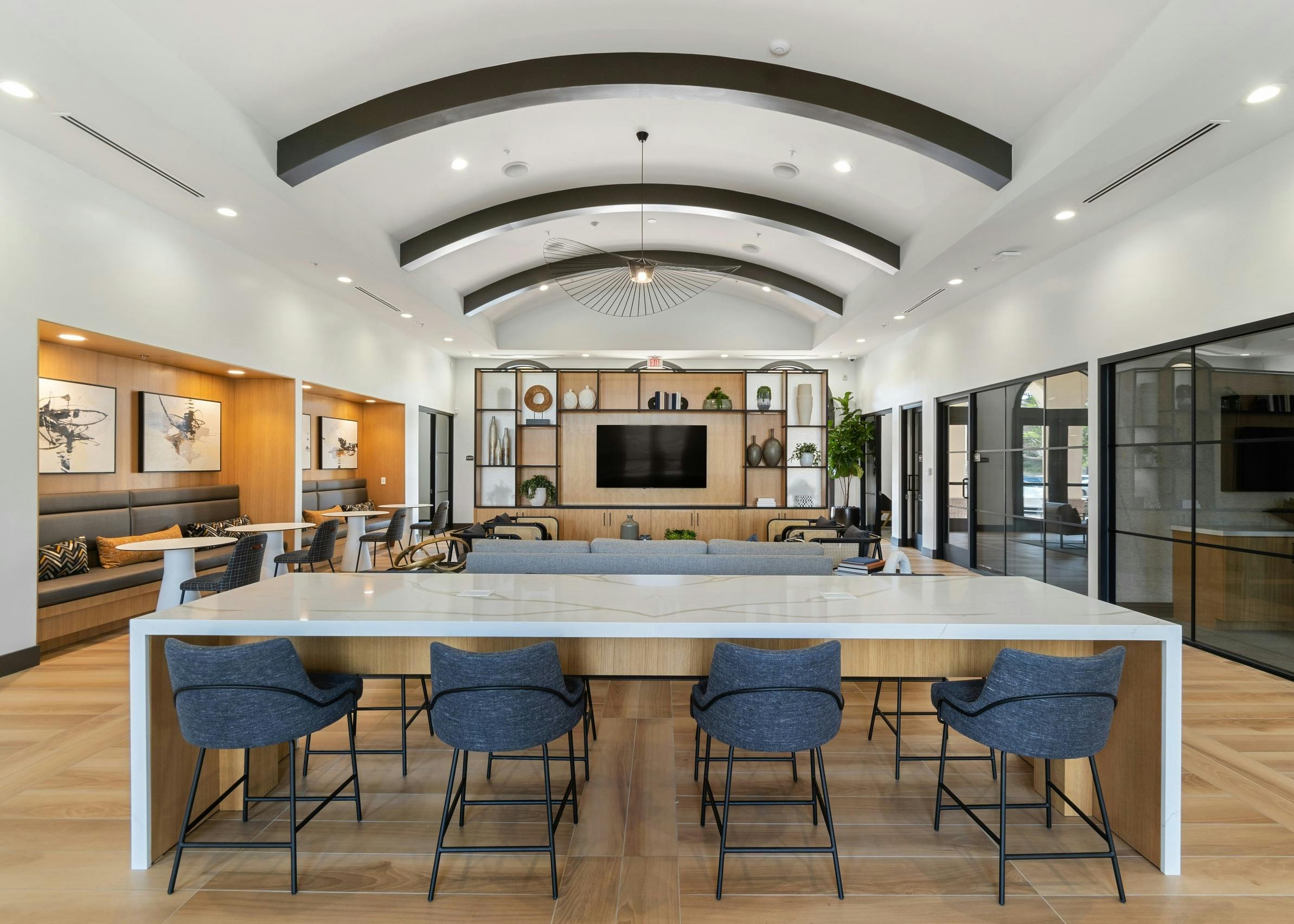Centered view of clubhouse at AMLI Spanish Hills apartments with quartz table and blue chairs and decorative light fixture