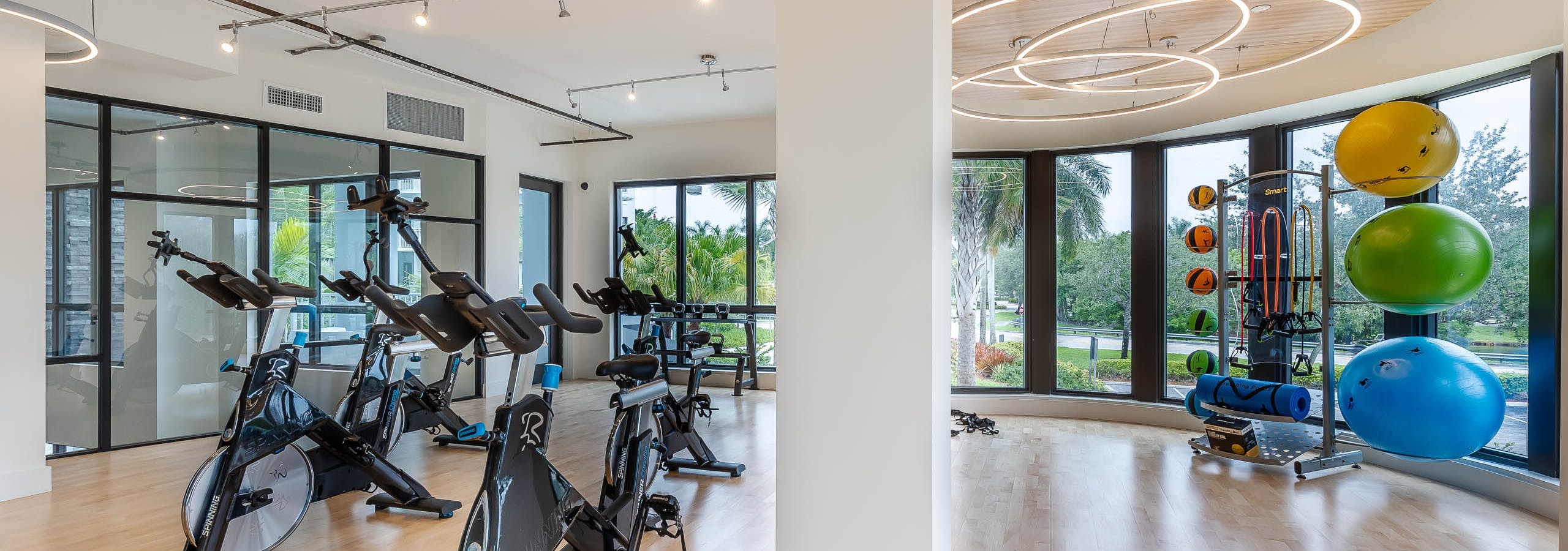 The AMLI Park West apartments yoga room with wood plank floors and spin bikes with exercise balls and circular lighting
