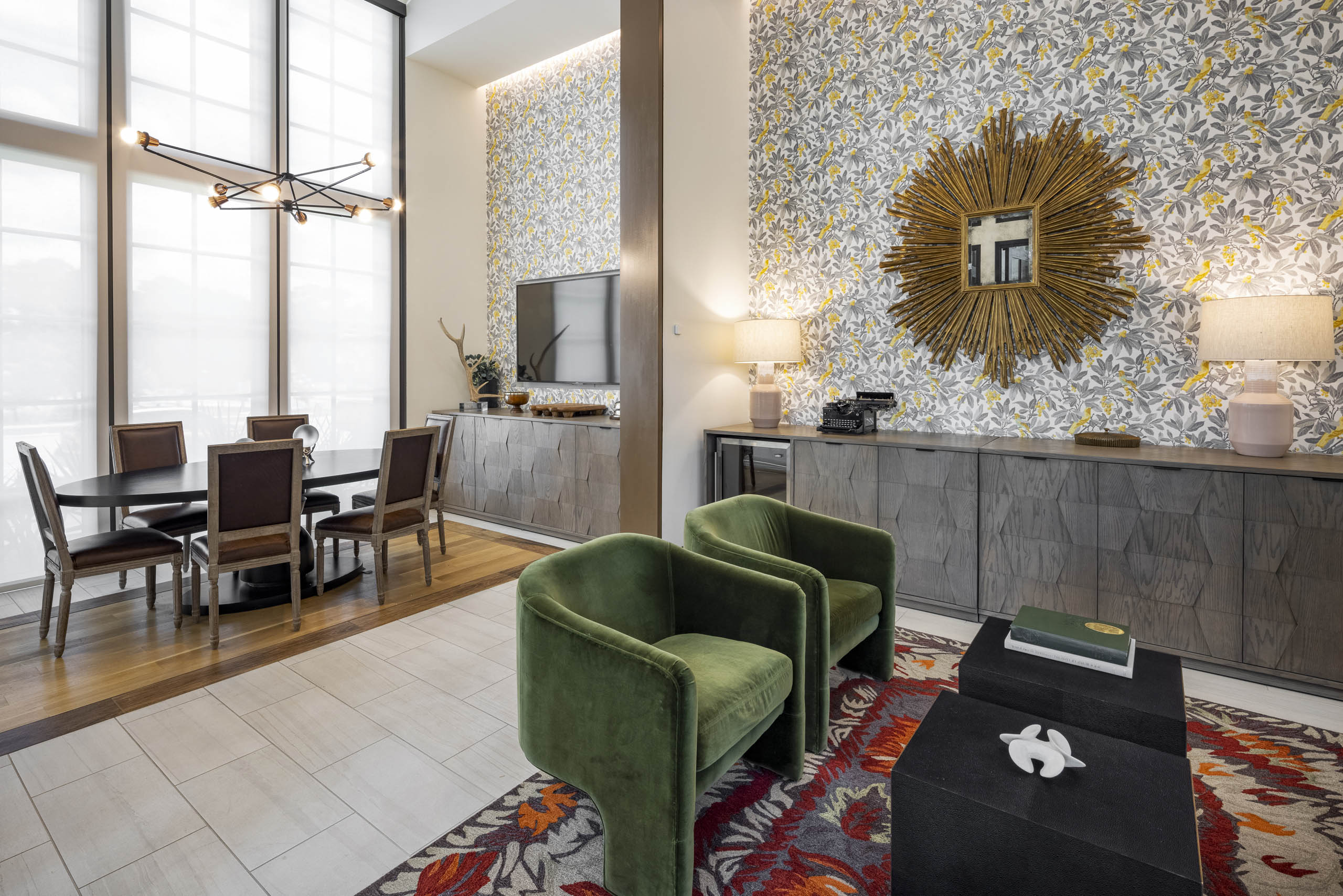 Business Center at AMLI Lakeline apartments including seating area with plush green chairs and an oval wooden conference table with wooden chairs