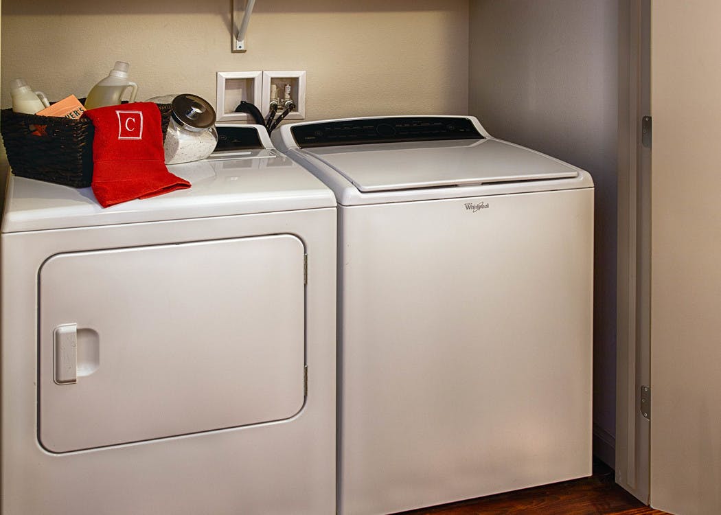 A laundry area at AMLI Denargo Market apartments with a white washer and dryer side by side with a view of the closet door