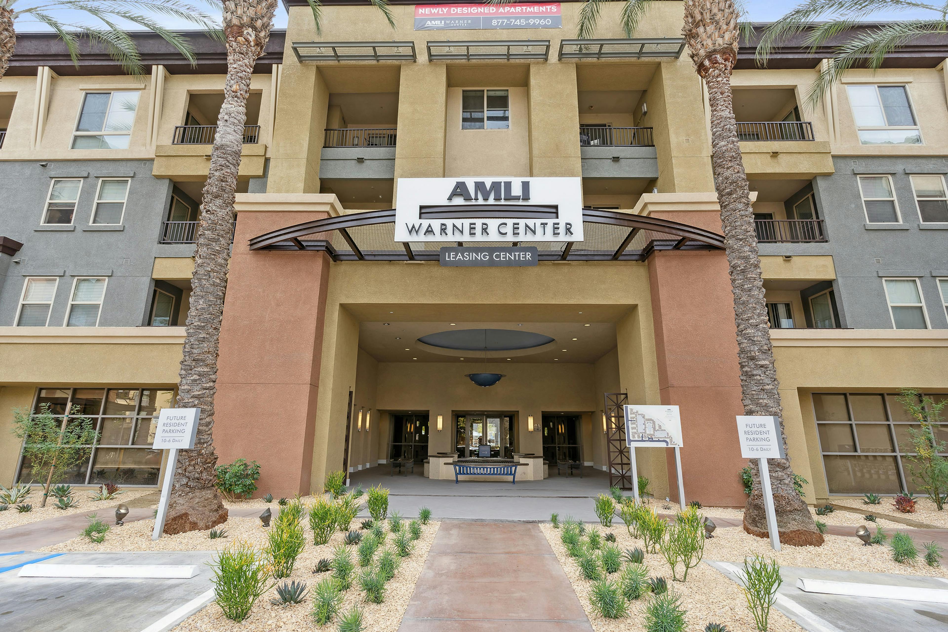 Daytime view of leasing office entrance with earth tone stucco façade at AMLI Warner Center apartments with logo sign above 