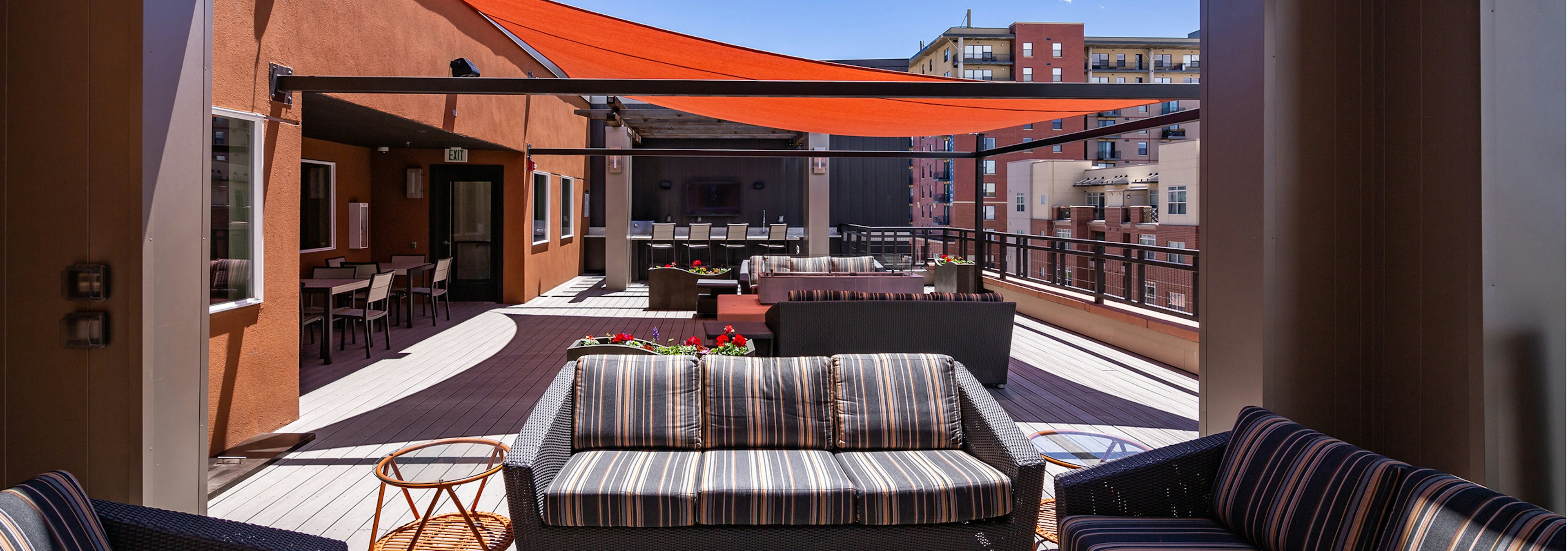 An exterior view of the rooftop at AMLI Riverfront Park apartments with multiple couches and end tables with view of blue sky