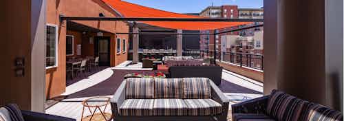 An exterior view of the rooftop at AMLI Riverfront Park apartments with multiple couches and end tables with view of blue sky