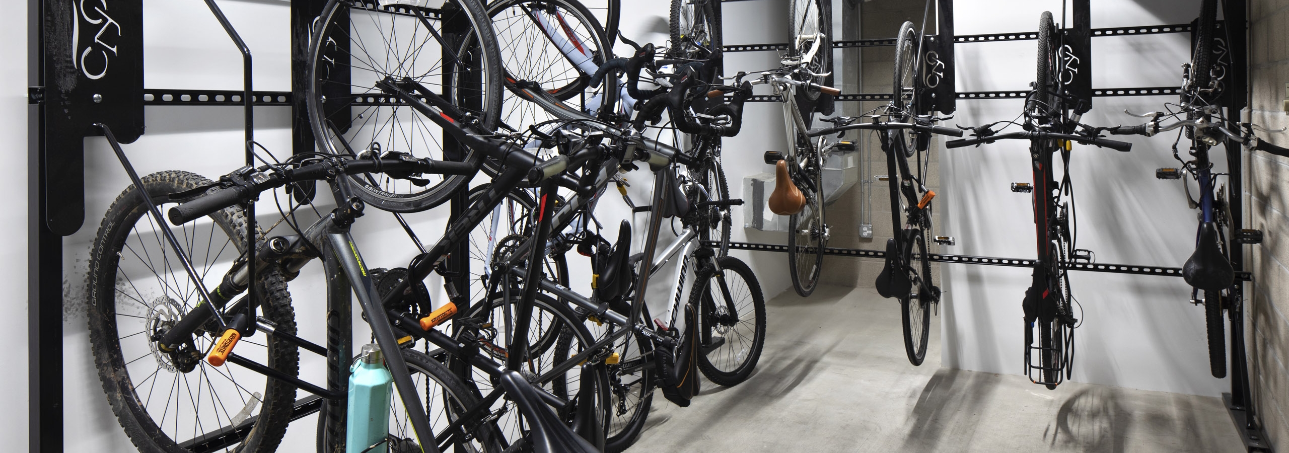 Interior view of the private bicycle storage room at AMLI Park Broadway apartment building with multiple hanging racks