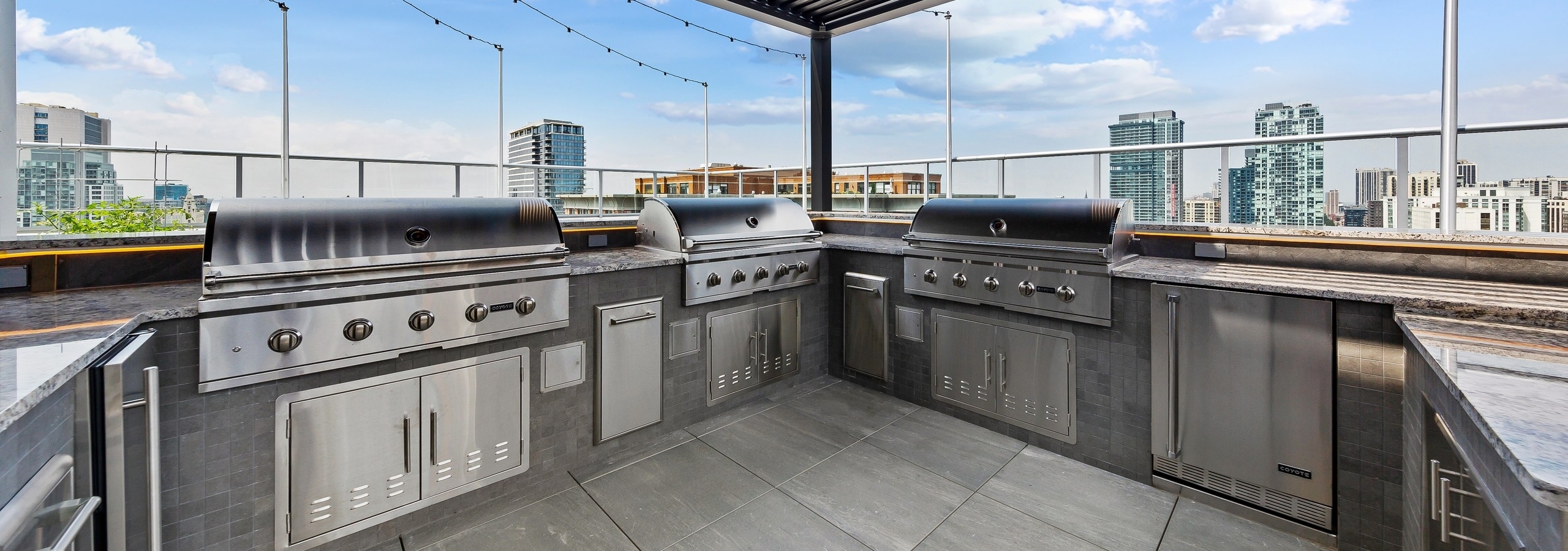 Spacious rooftop stainless steel grill station at the AMLI 808 apartment building surrounded by gorgeous Chicago skyline