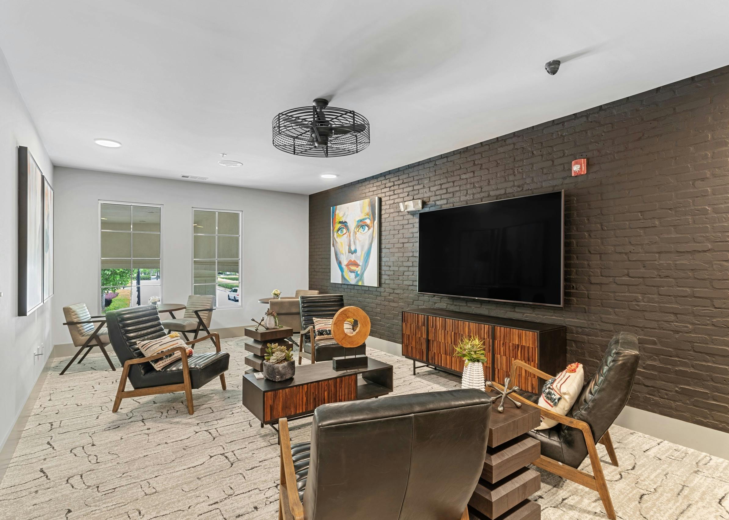Cyber cafe at AMLI North Point apartments with painted brick wall and TV on wall with armchair seating and side window