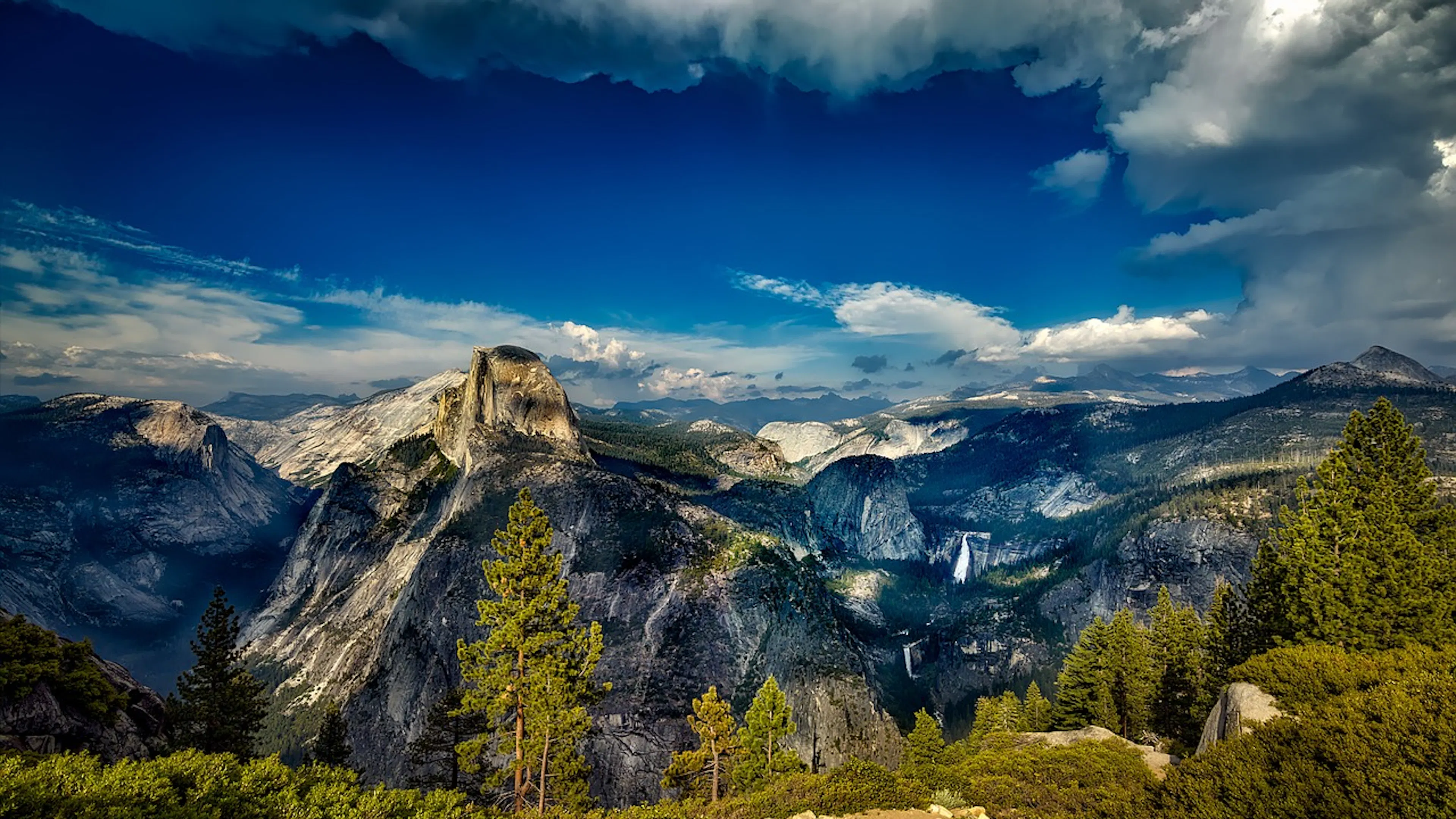 A sweeping view of Yosemite National Park with cloud shadows dotting the landscape