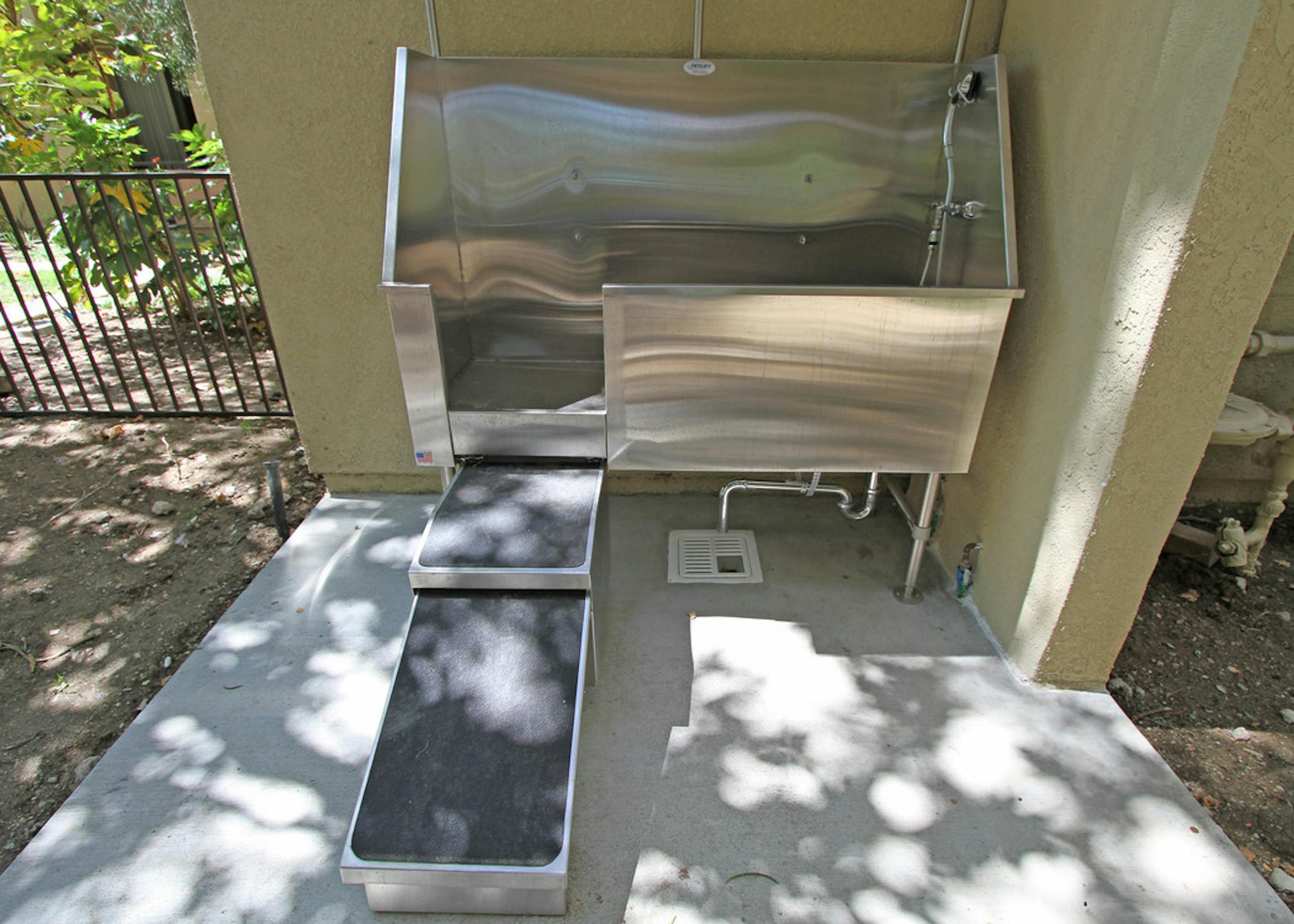Daytime view of stainless steel pet wash station, detachable shower head and walk-up ramp at AMLI Warner Center apartments