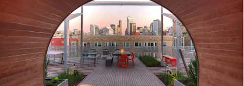 View of Downtown Seattle from the AMLI South Lake Union rooftop with fire pit lush landscape and seating