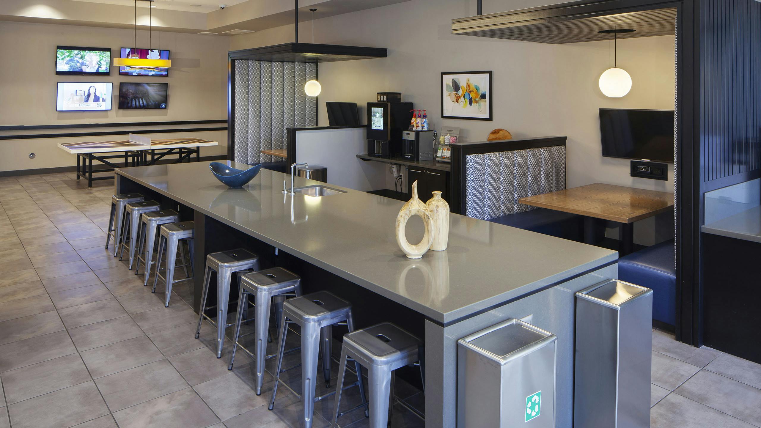 AMLI Cherry Creek game lounge with table tennis and coffee machine and hanging lights and a long table with metal bar stools