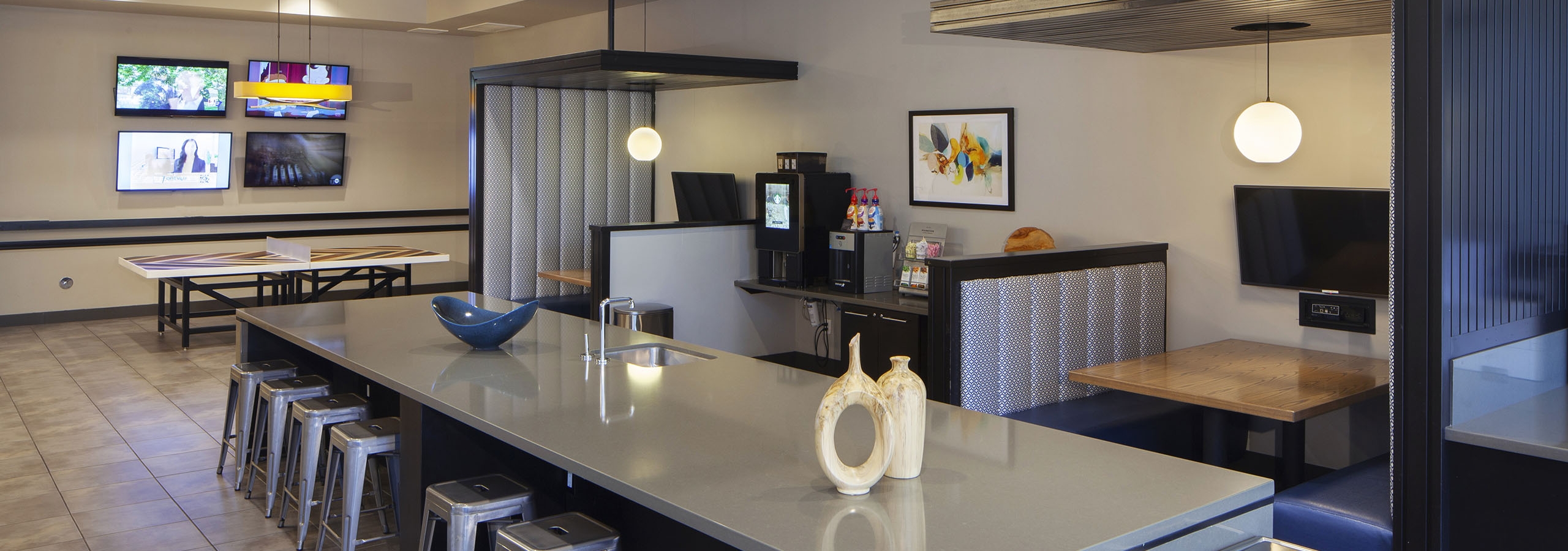 AMLI Cherry Creek game lounge with table tennis and coffee machine and hanging lights and a long table with metal bar stools
