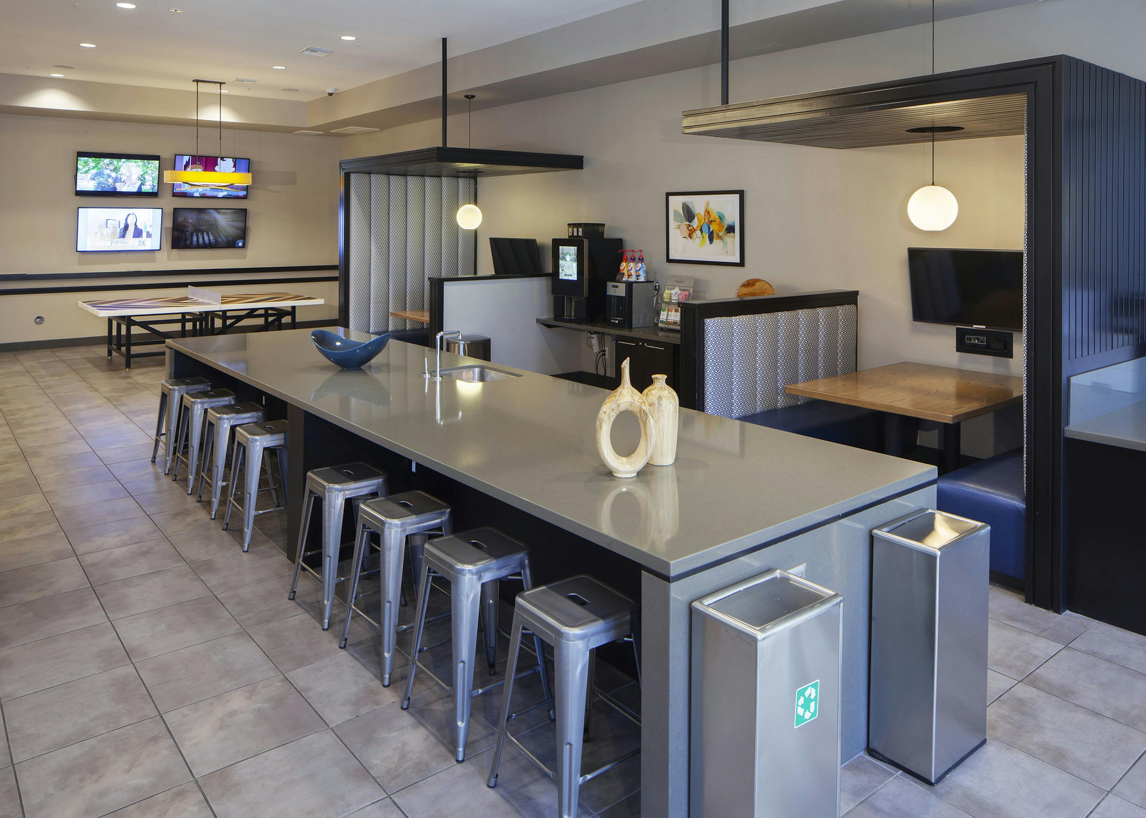 AMLI Cherry Creek game lounge with table tennis and coffee machine and hanging lights and a long table with metal bar stools