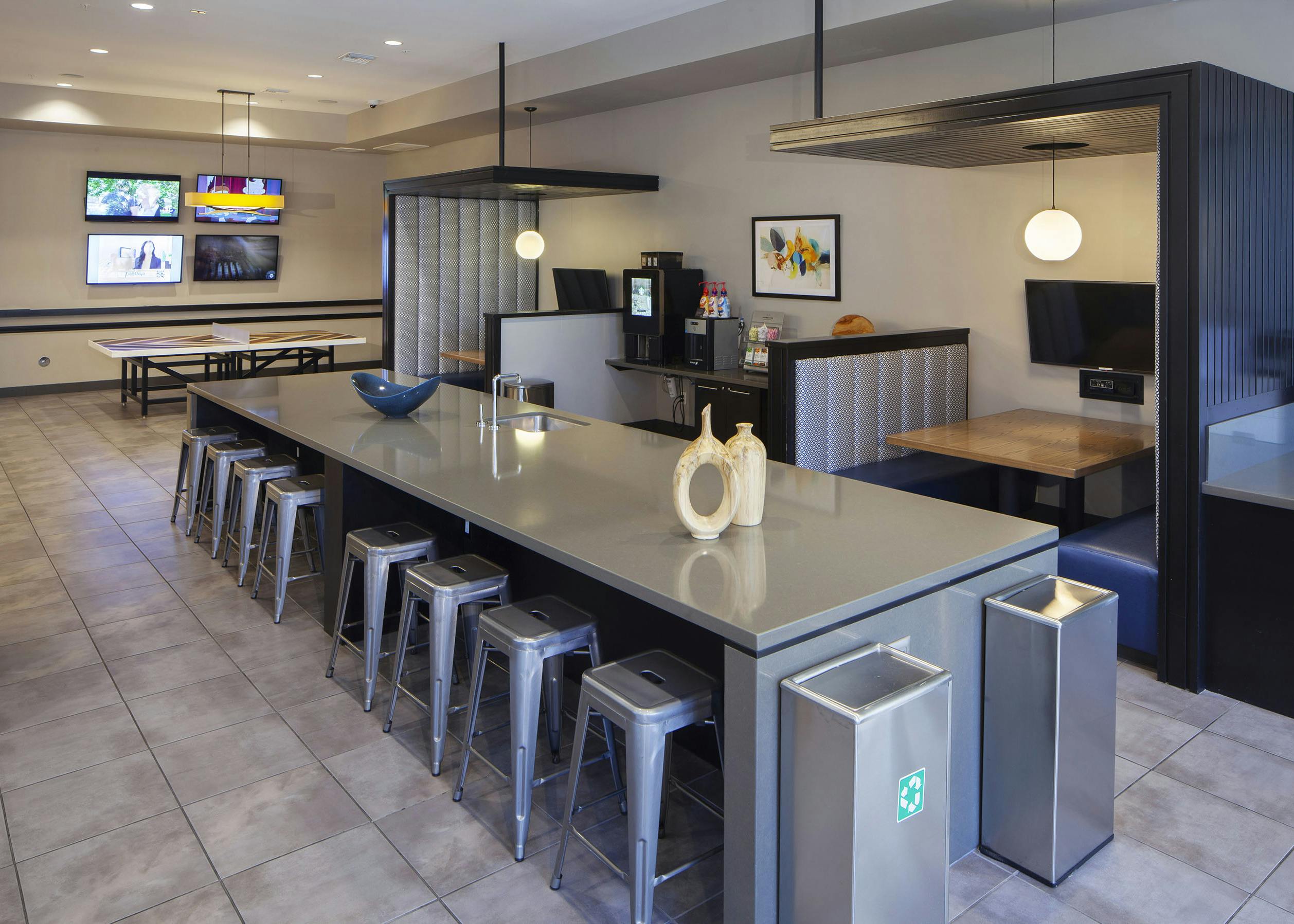 AMLI Cherry Creek game lounge with table tennis and coffee machine and hanging lights and a long table with metal bar stools