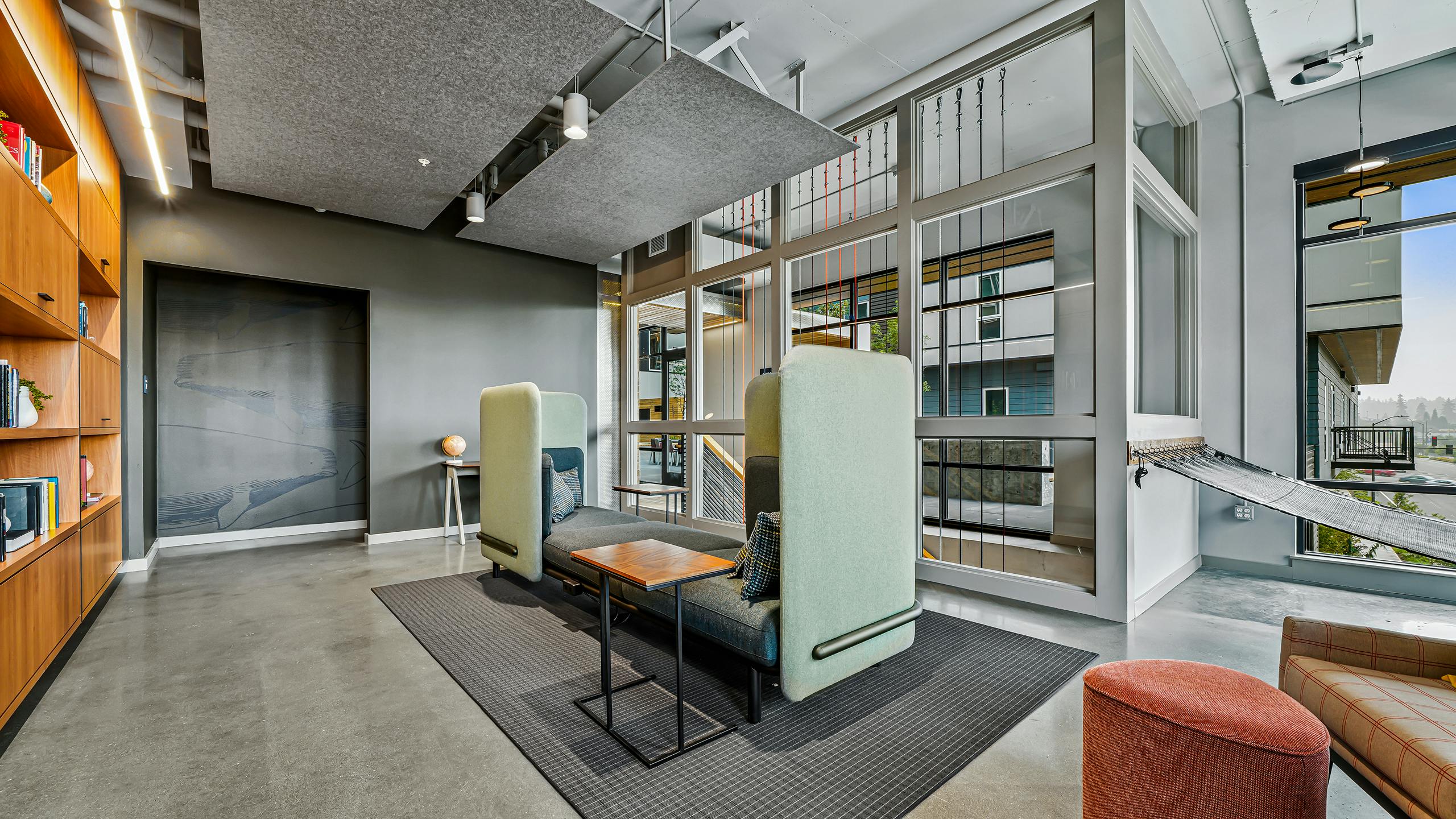 AMLI Spring District library with high ceilings and comfy booth at the center of the room and wood wall of bookshelves