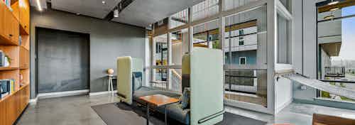 AMLI Spring District library with high ceilings and comfy booth at the center of the room and wood wall of bookshelves