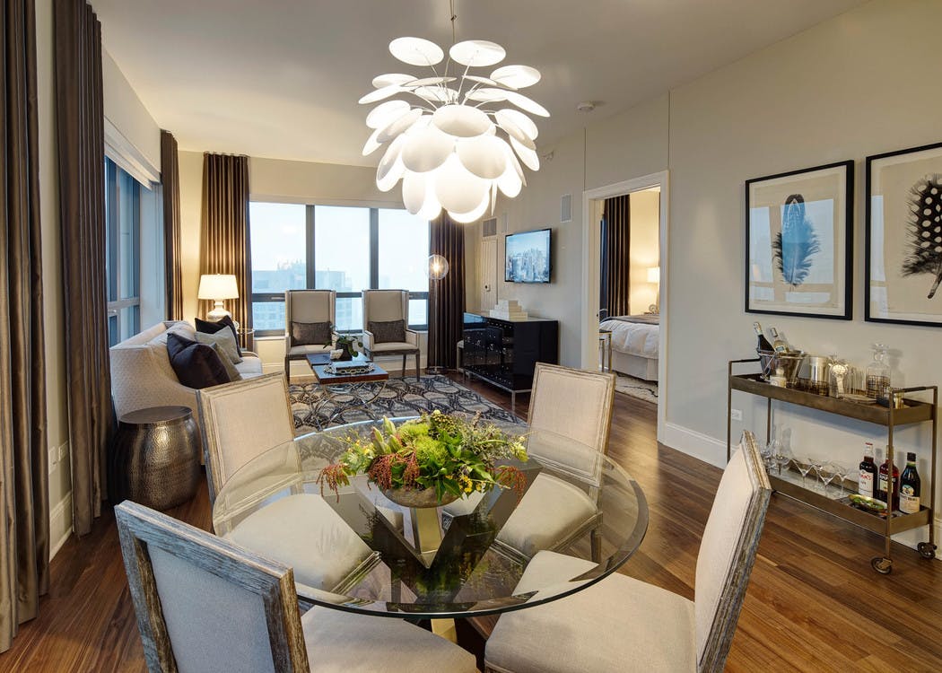 AMLI River North penthouse living room with multiple windows bringing in natural light with wood floors with vintage decor