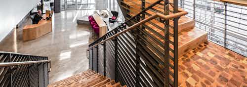 Interior lobby of AMLI Arc with large wooden staircase and view of lobby with ample seating concierge desk and leasing office