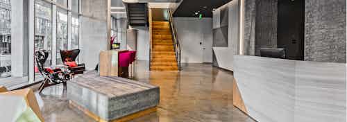 Interior lobby of AMLI Arc with seating floor to ceiling windows wooden stairs leading to leasing office and concierge desk