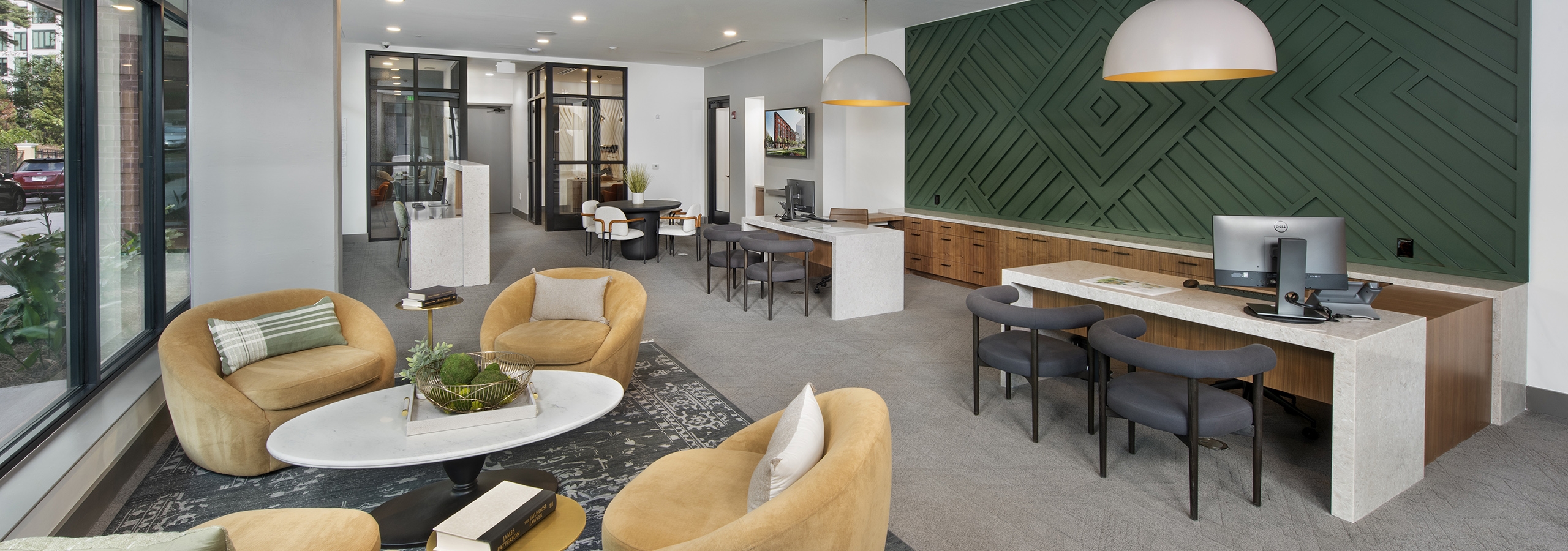 AMLI Flatiron leasing office with stuffed yellow chairs and coffee white table and white desks with grey chairs by dark green wall