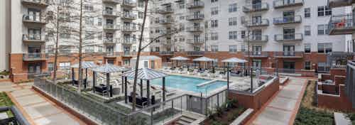 Aerial view of AMLI Downtown apartment building courtyard pool surrounded by cabanas and lounge seating and lush landscaping