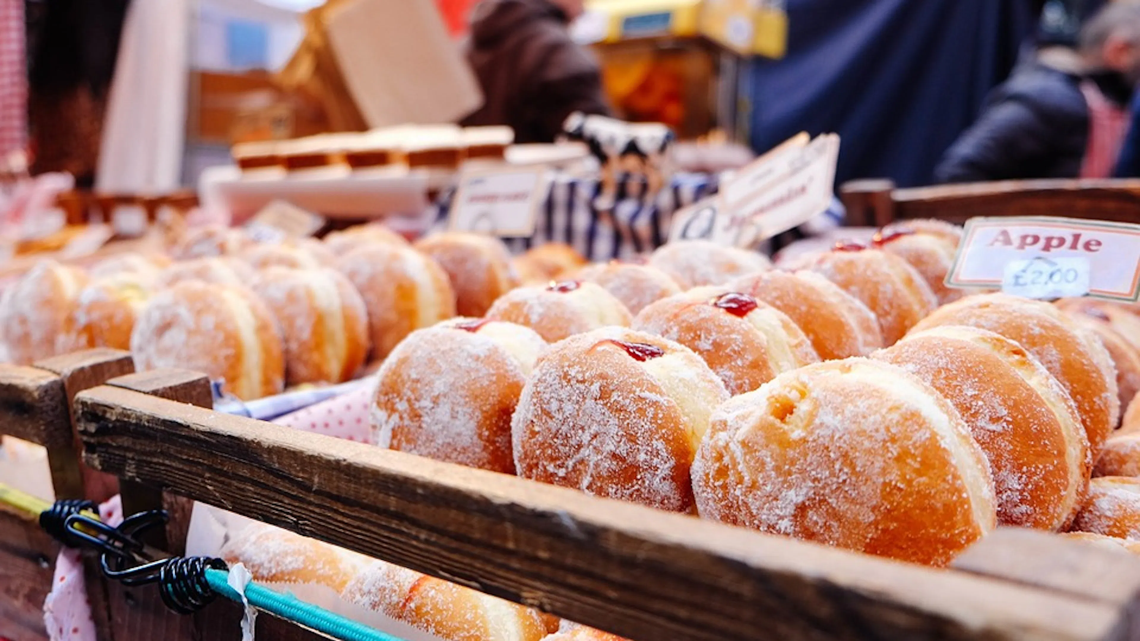 Wooden fruit crates filled with rows of strawberry jelly doughnuts