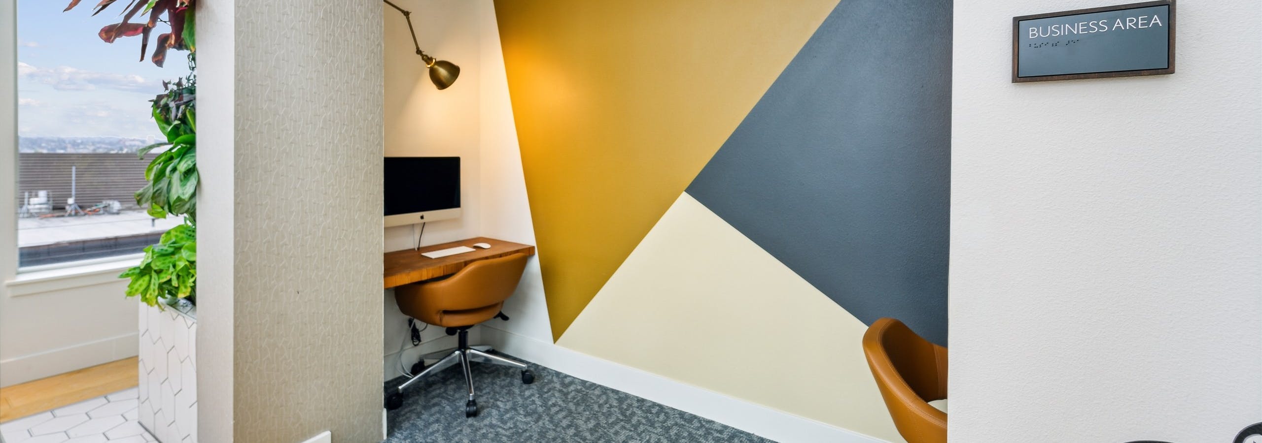 Business area at AMLI South Lake Union with two desks and computers with rolling chairs and overhead lamp lighting