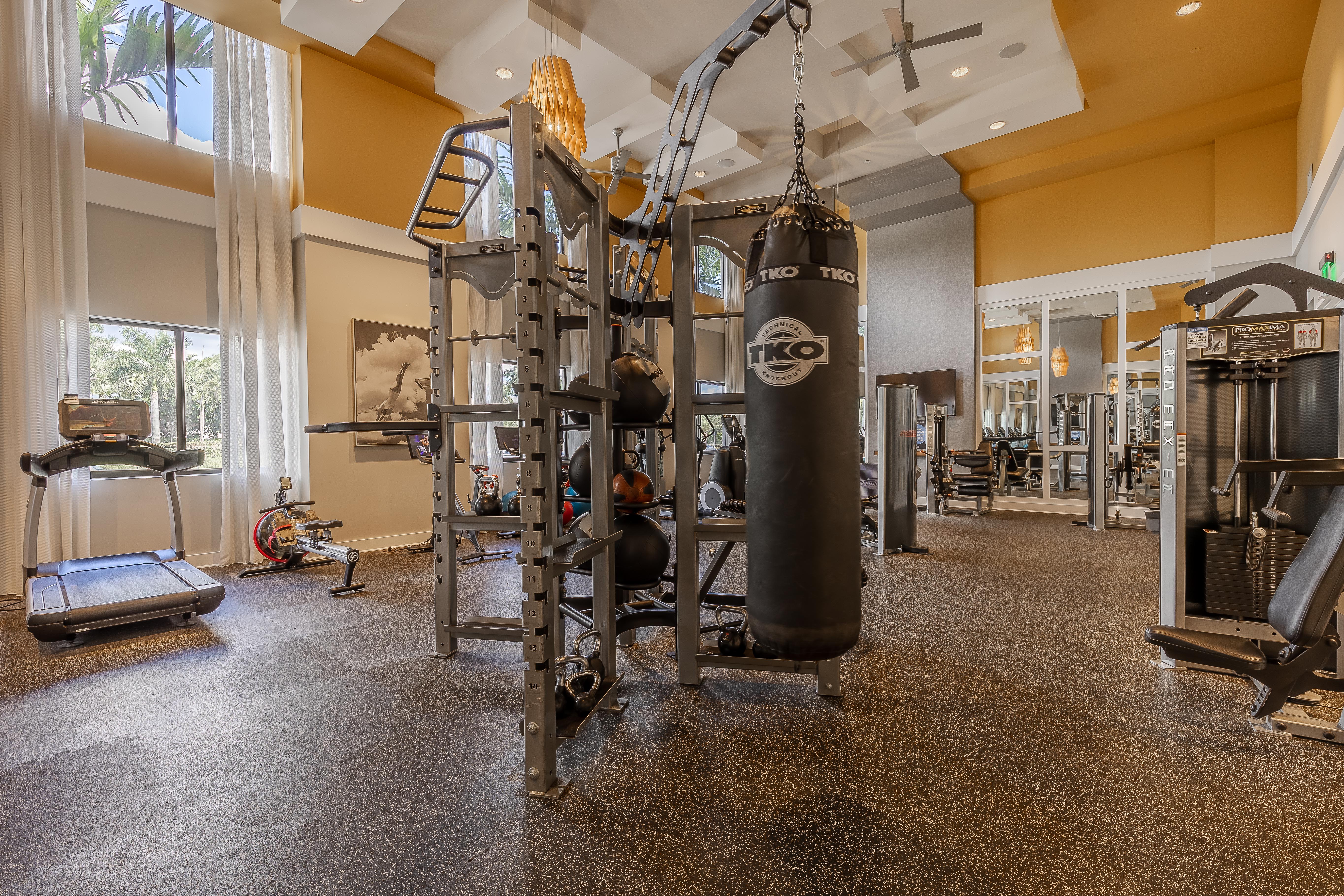 Interior view of the AMLI 8800 apartment fitness center with workout machines and a punching bag with high ceilings 