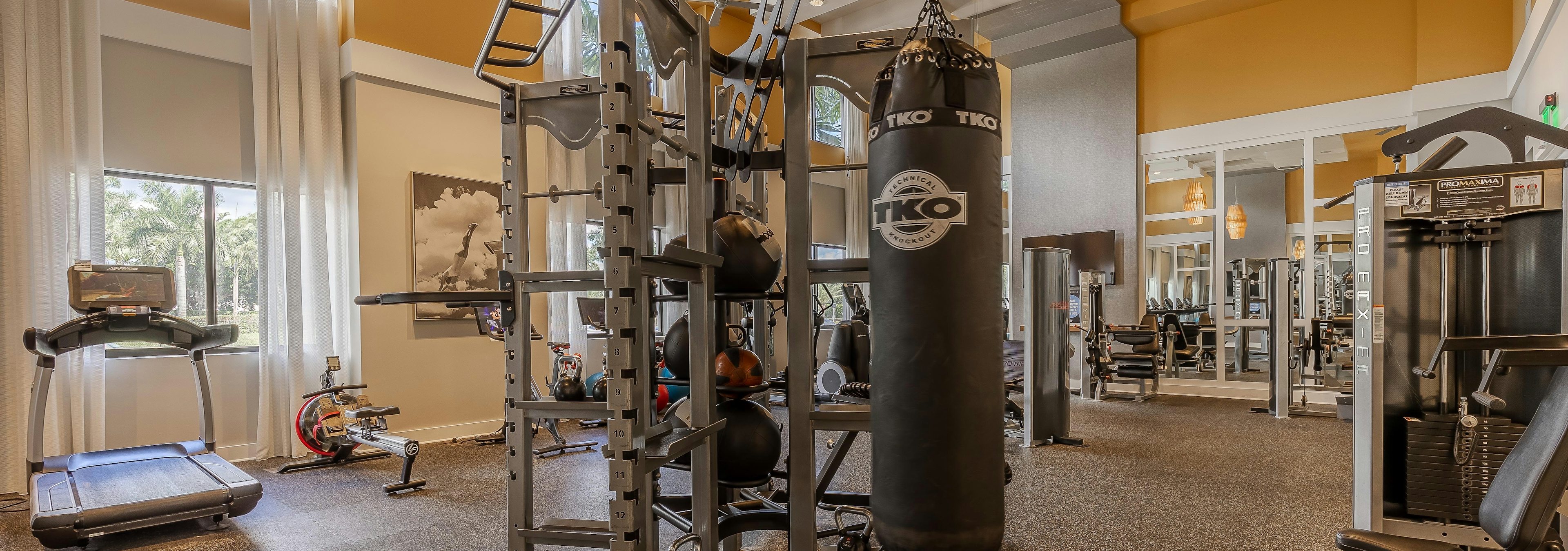 Interior view of the AMLI 8800 apartment fitness center with workout machines and a punching bag with high ceilings