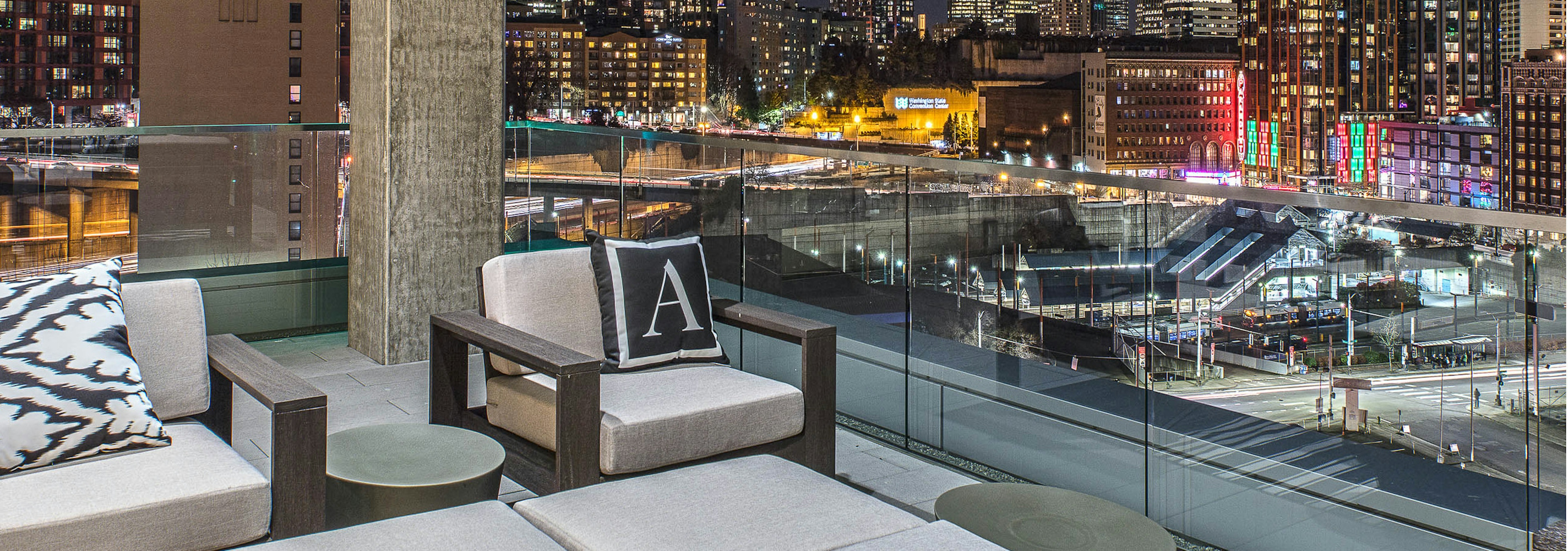 Exterior deck of AMLI Arc with seating and views of Downtown Seattle  