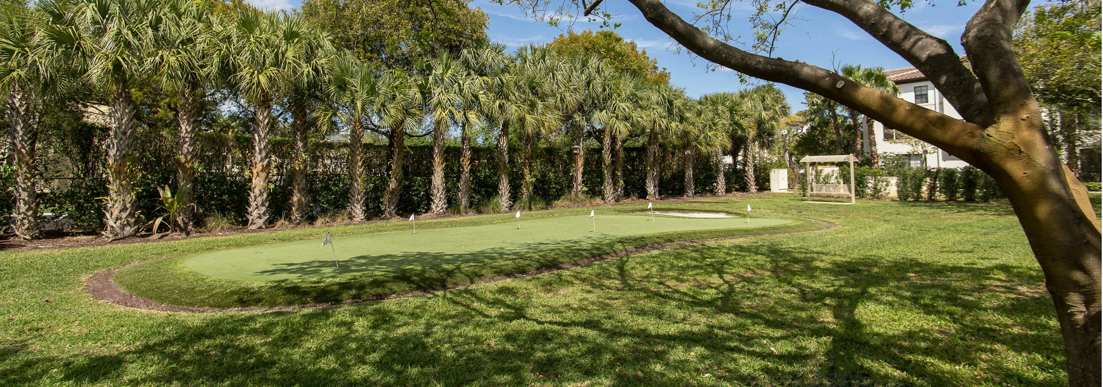 AMLI Toscana Place outdoor putting green lined with palm trees and replicated greens to putt 