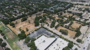Aerial view of AMLI Tree House apartments empty dirt land parcel with demolition completed and many mature trees