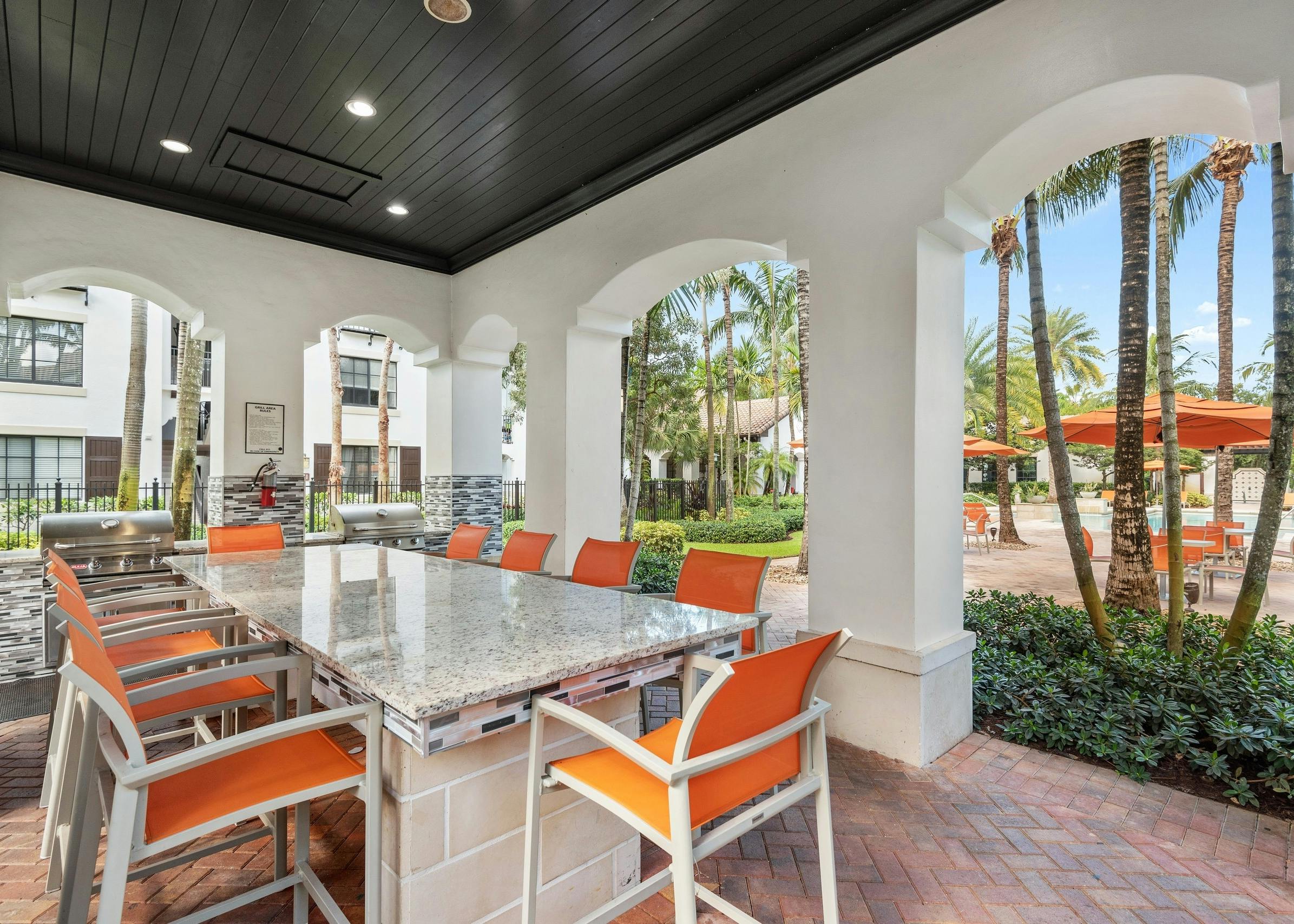 Daytime view of AMLI Toscana Place built in barbeque seating area with free standing island and high top seating