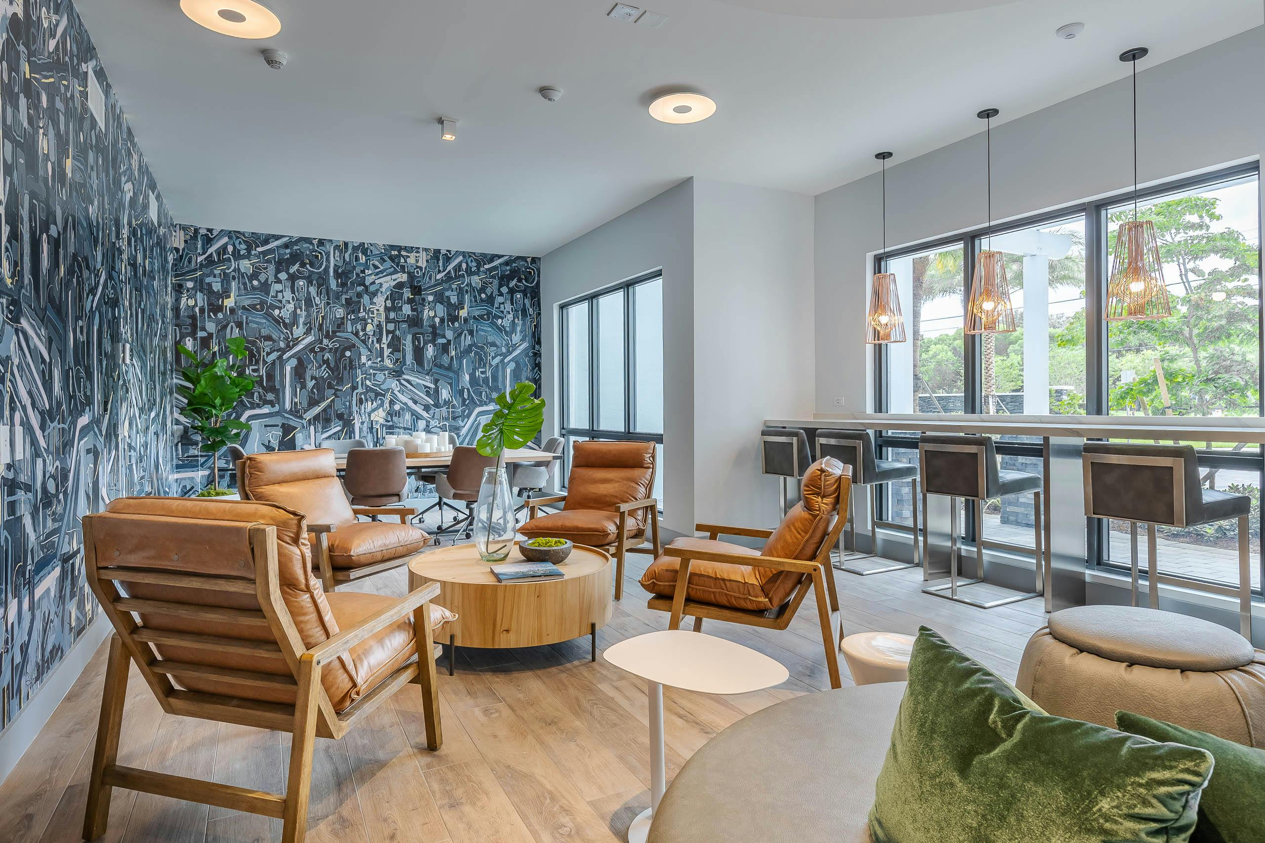 The AMLI Park West inspiration station lounge with black and white geometric wall mural with lounge seating and wood table