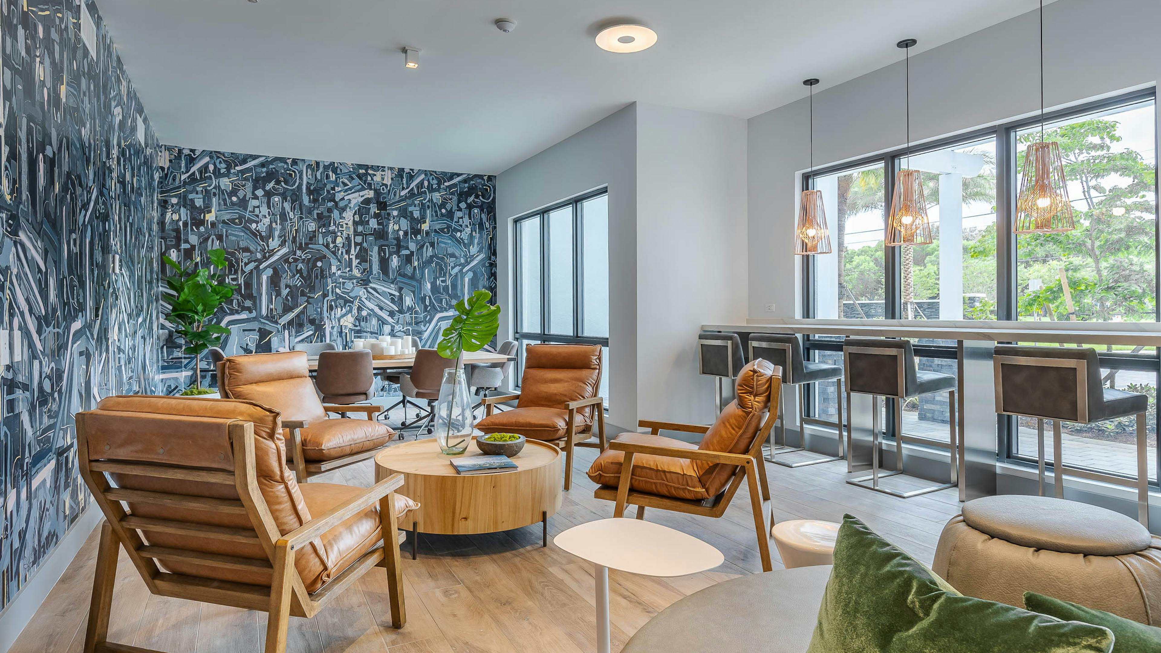 The AMLI Park West inspiration station lounge with black and white geometric wall mural with lounge seating and wood table 