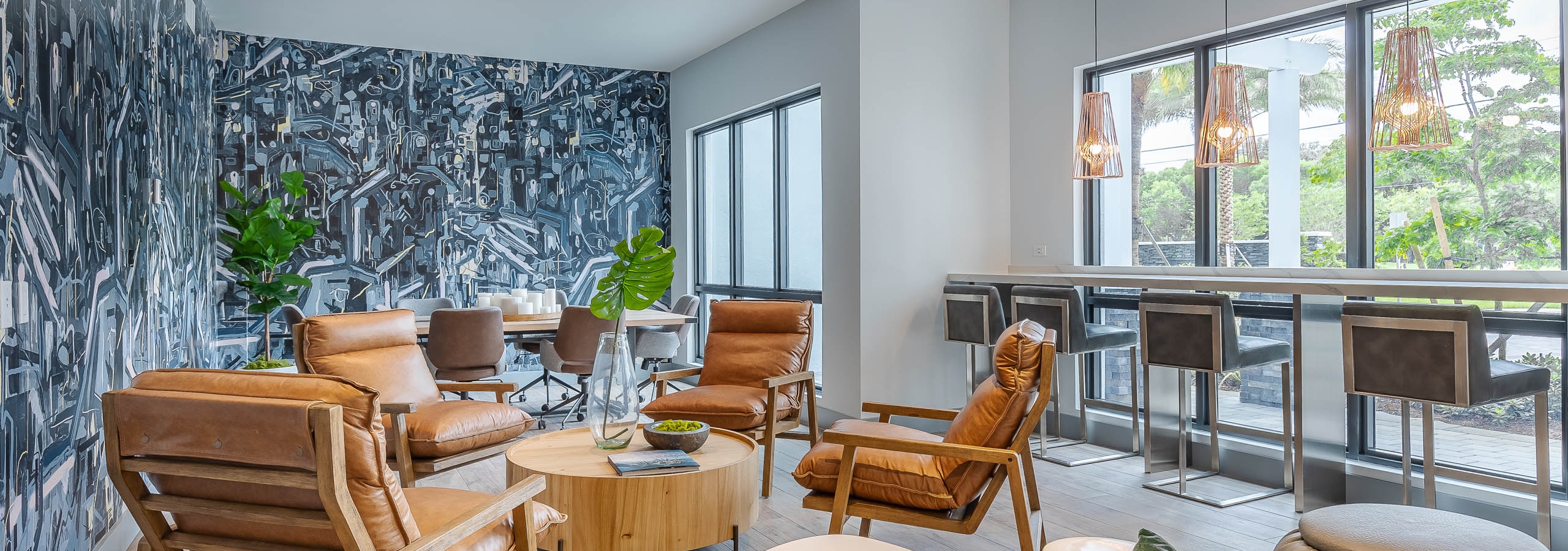 The AMLI Park West inspiration station lounge with black and white geometric wall mural with lounge seating and wood table