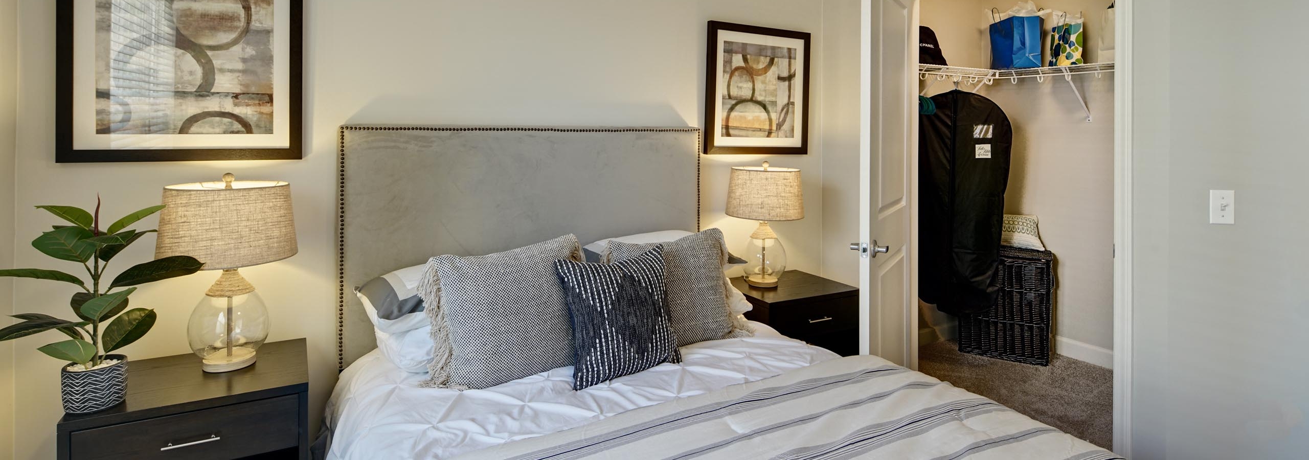 Close up of large bed in an AMLI Evanston apartment bedroom with view of open door leading to spacious walk in closet