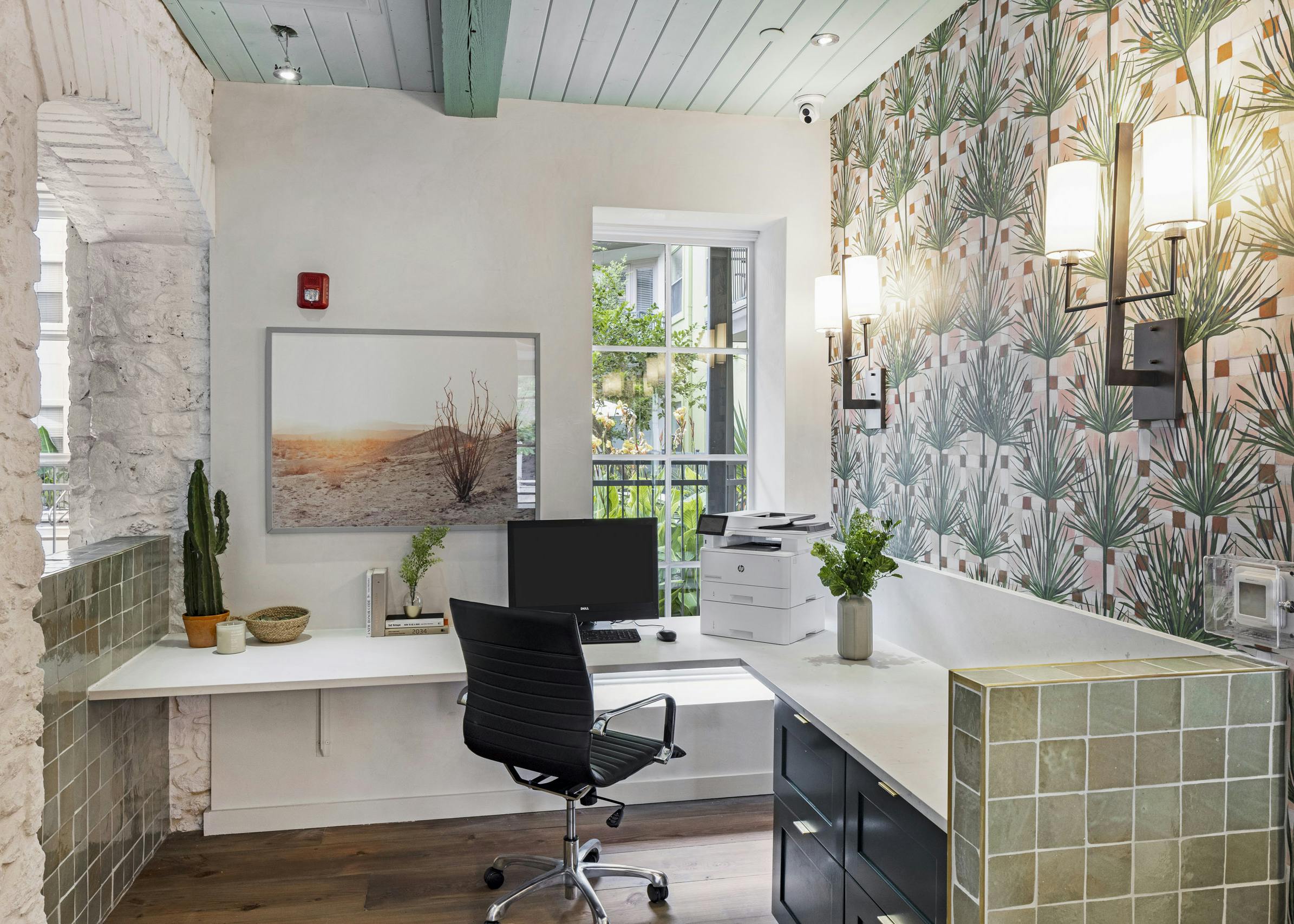 AMLI 300 business center with white corner desk with computer and printer with green tile detailing and patterned wallpaper