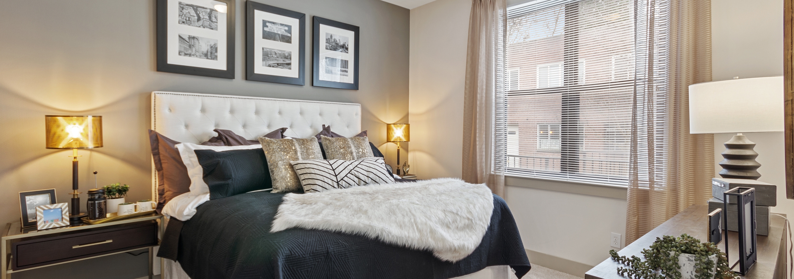 AMLI Old 4th Ward bedroom with grey accent wall and high ceilings with carpet floors and a large window for natural sunlight