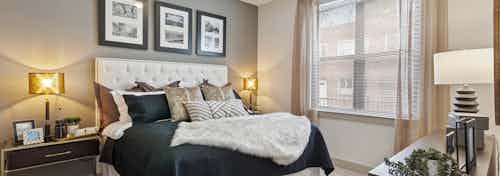 AMLI Old 4th Ward bedroom with grey accent wall and high ceilings with carpet floors and a large window for natural sunlight