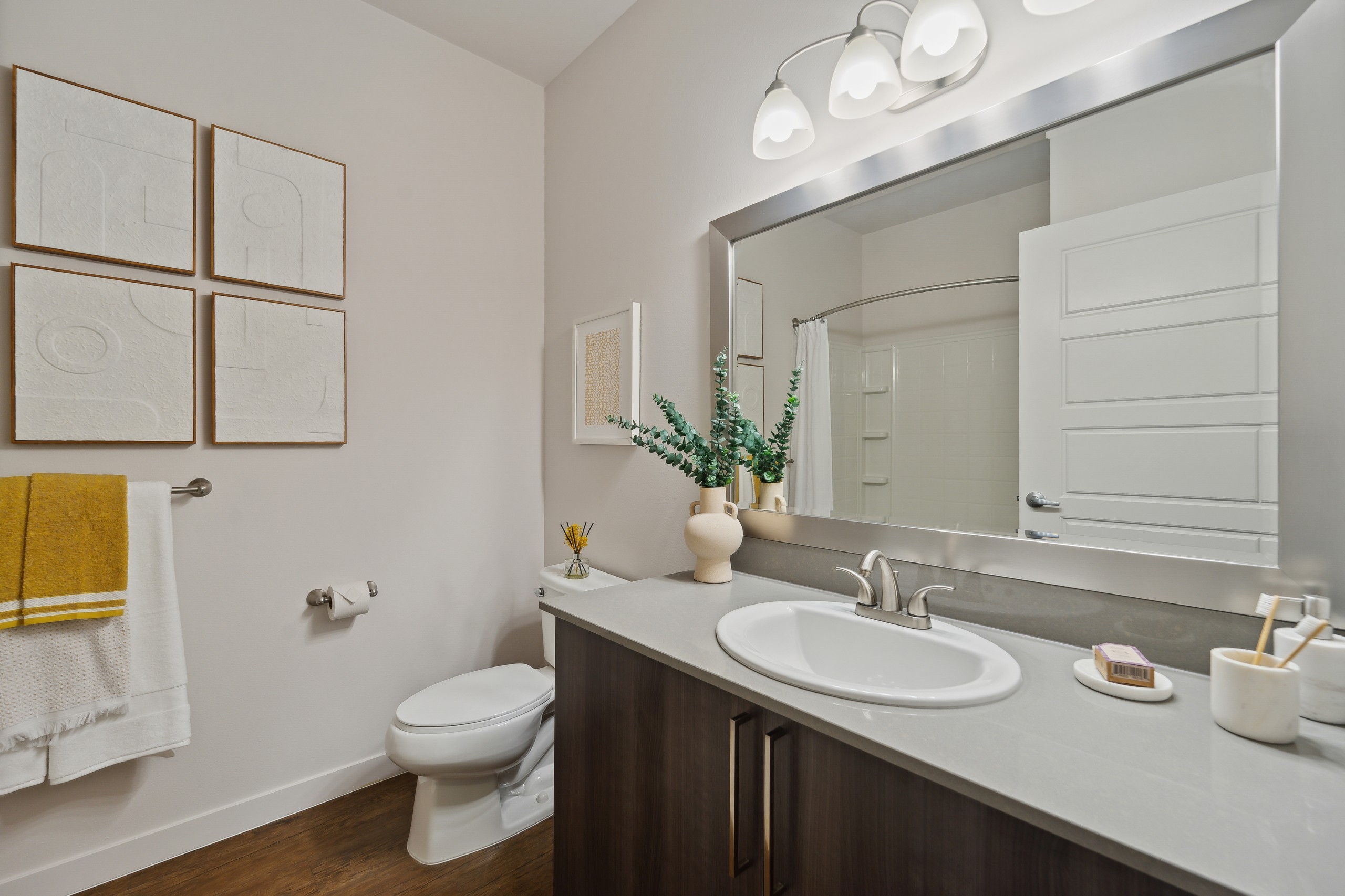 AMLI South Lake Union bathroom featuring a large mirror above a long vanity with single white sink and brushed nickel faucet