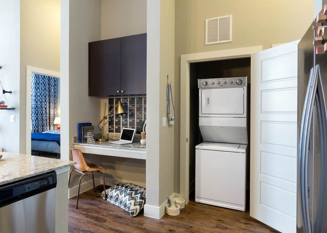 View from kitchen at AMLI on Riverside with a built in desk next to closet that opens up to reveal stacked washer and dryer