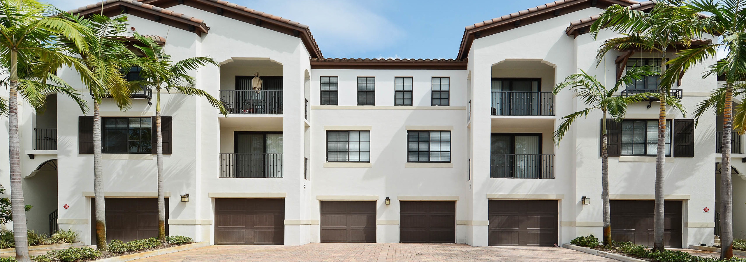 AMLI Toscana Place one car brown parking garages attached to the exterior of apartment building surrounded by palm trees