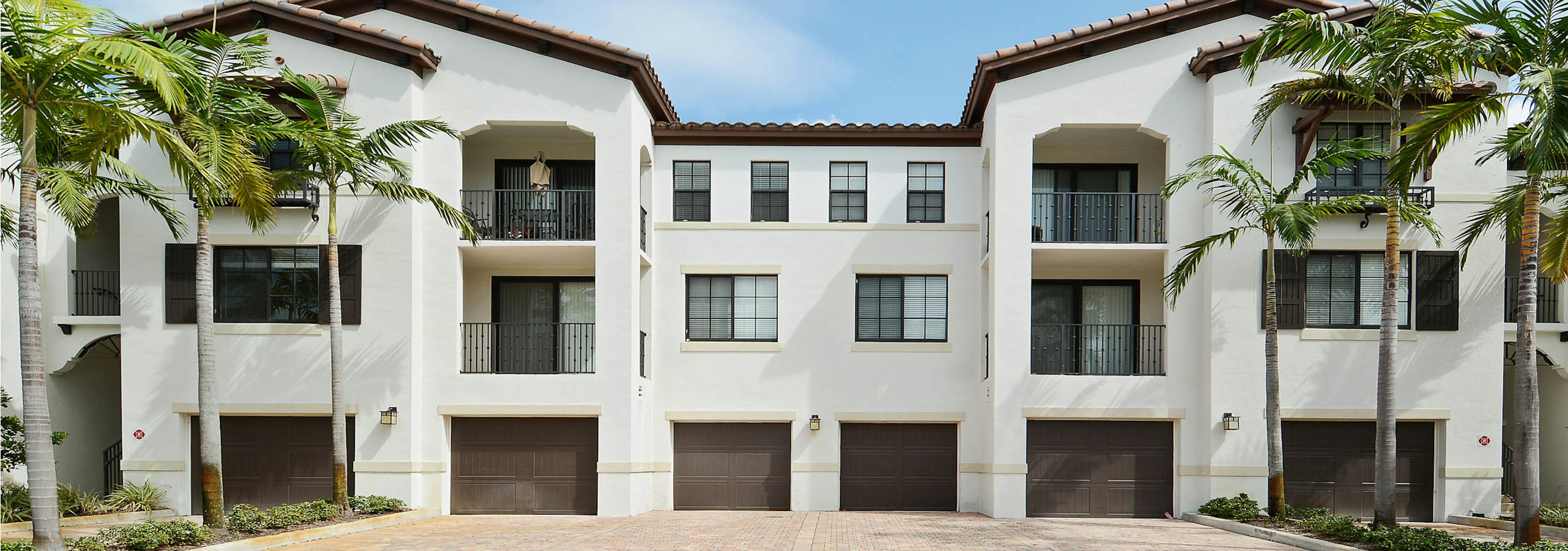 AMLI Toscana Place one car brown parking garages attached to the exterior of apartment building surrounded by palm trees 