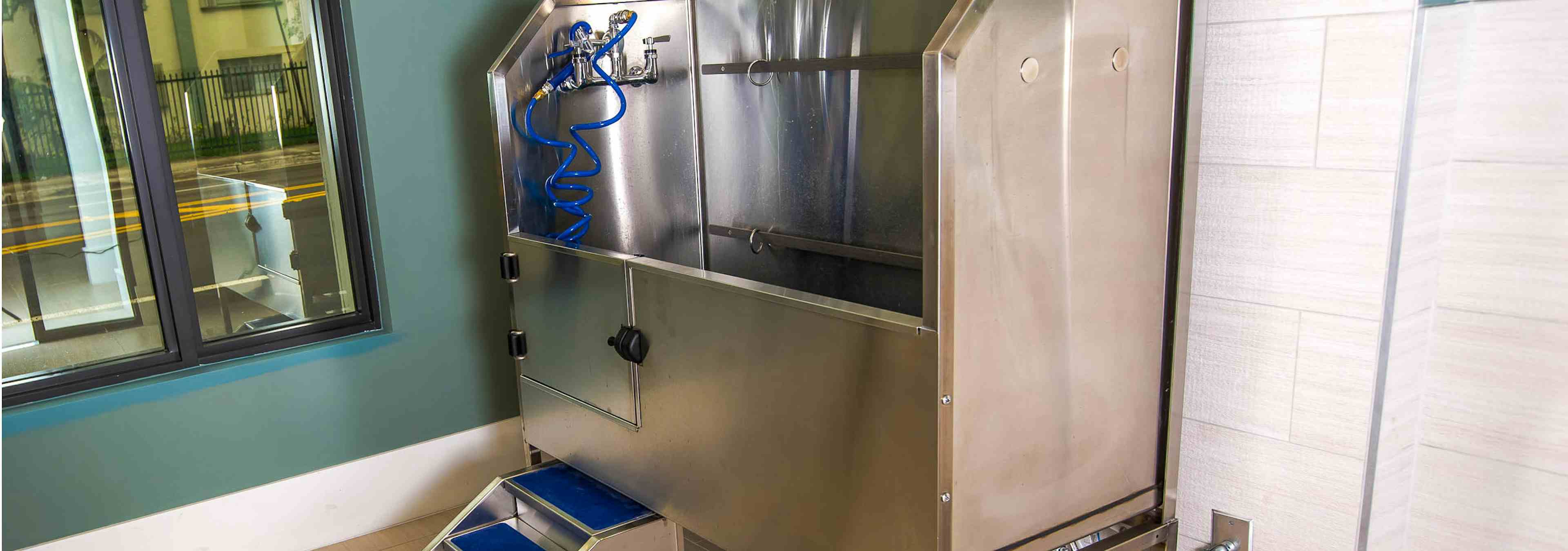 Interior view of the paw wash at AMLI Joya with large stainless steel tub, walk up ramp and hose 