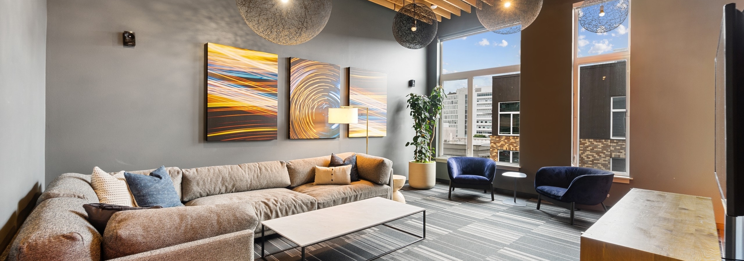 Interior view of rooftop lounge at AMLI South Lake union with couches and coffee table and vibrant wall paintings