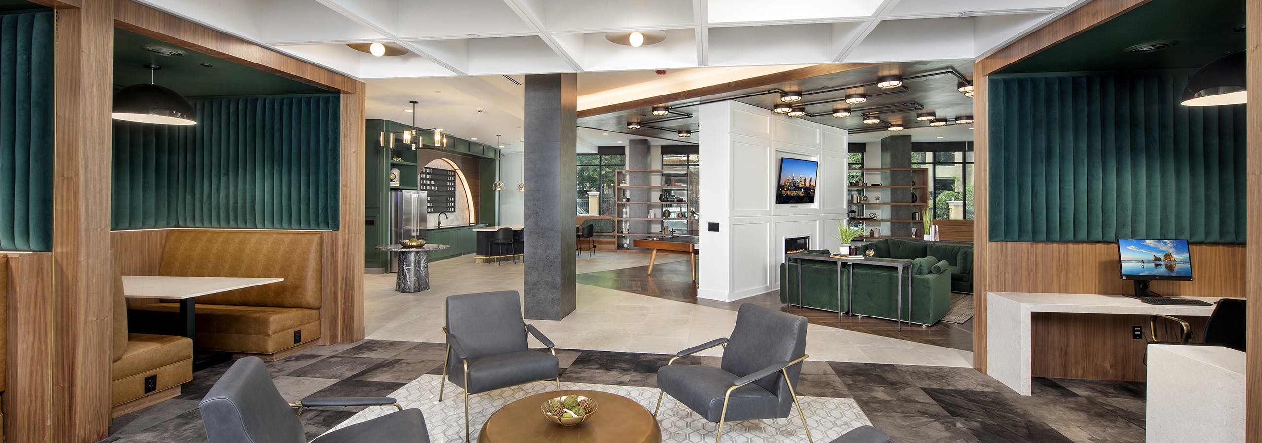 AMLI Flatiron clubhouse with grey chairs and gold coffee table with tan and green banquet seating and coffered ceiling